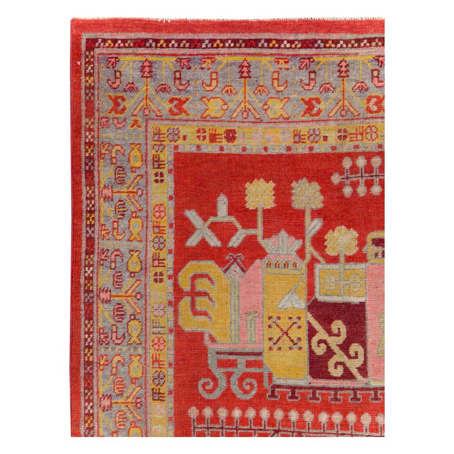 An antique East Turkestan Khotan small gallery rug handmade during the early 20th century with a pictorial vase design over a red field.

Measures: 4' 5