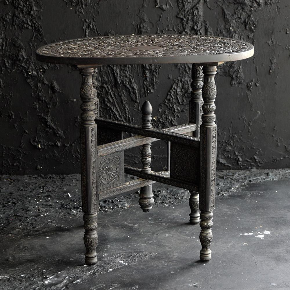 Early 20th century ebonised hand carved Jaipur folding side table 

An elegant and stylish example of an early 20th Century Jaipur Indian folding ebonised hand carved side table. With intricate carved geometric floral details across all its