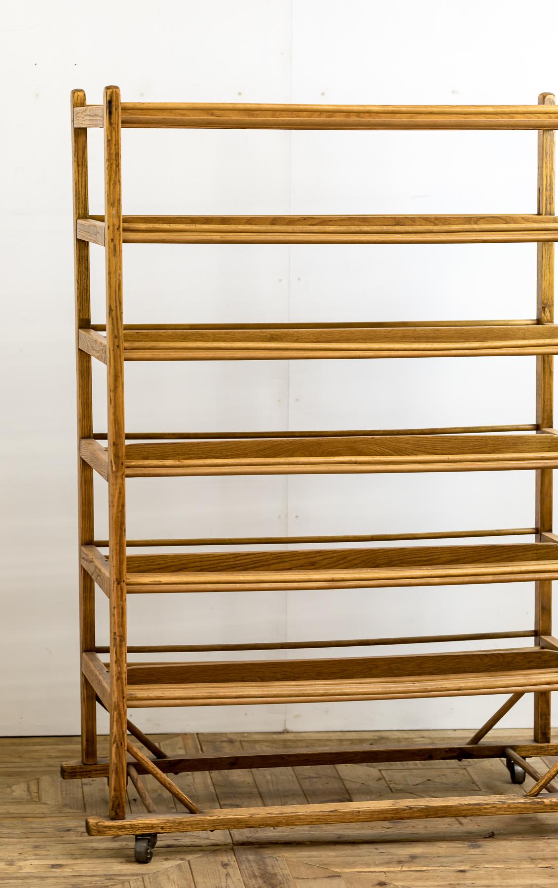 An Industrial bakery cooling rack of traditional form on six tiers and raised on industrial casters.