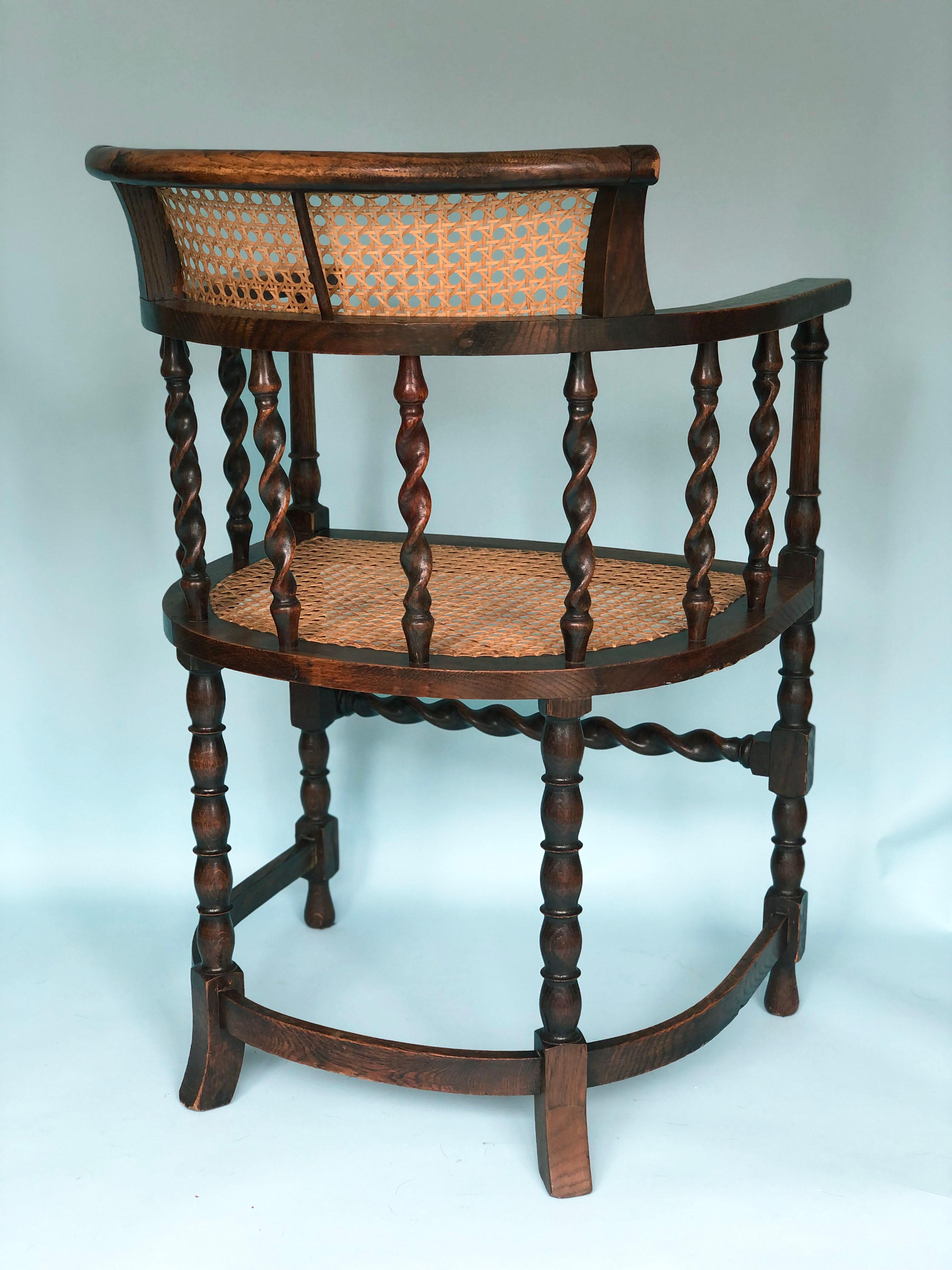 An English corner chair with barley twist supports and bobbin turned legs from the early 20th century. The beech wood chair and cane are in good condition. The cane seat is from a later period. 

Object: Armchair
Designer: Unknown
Style: