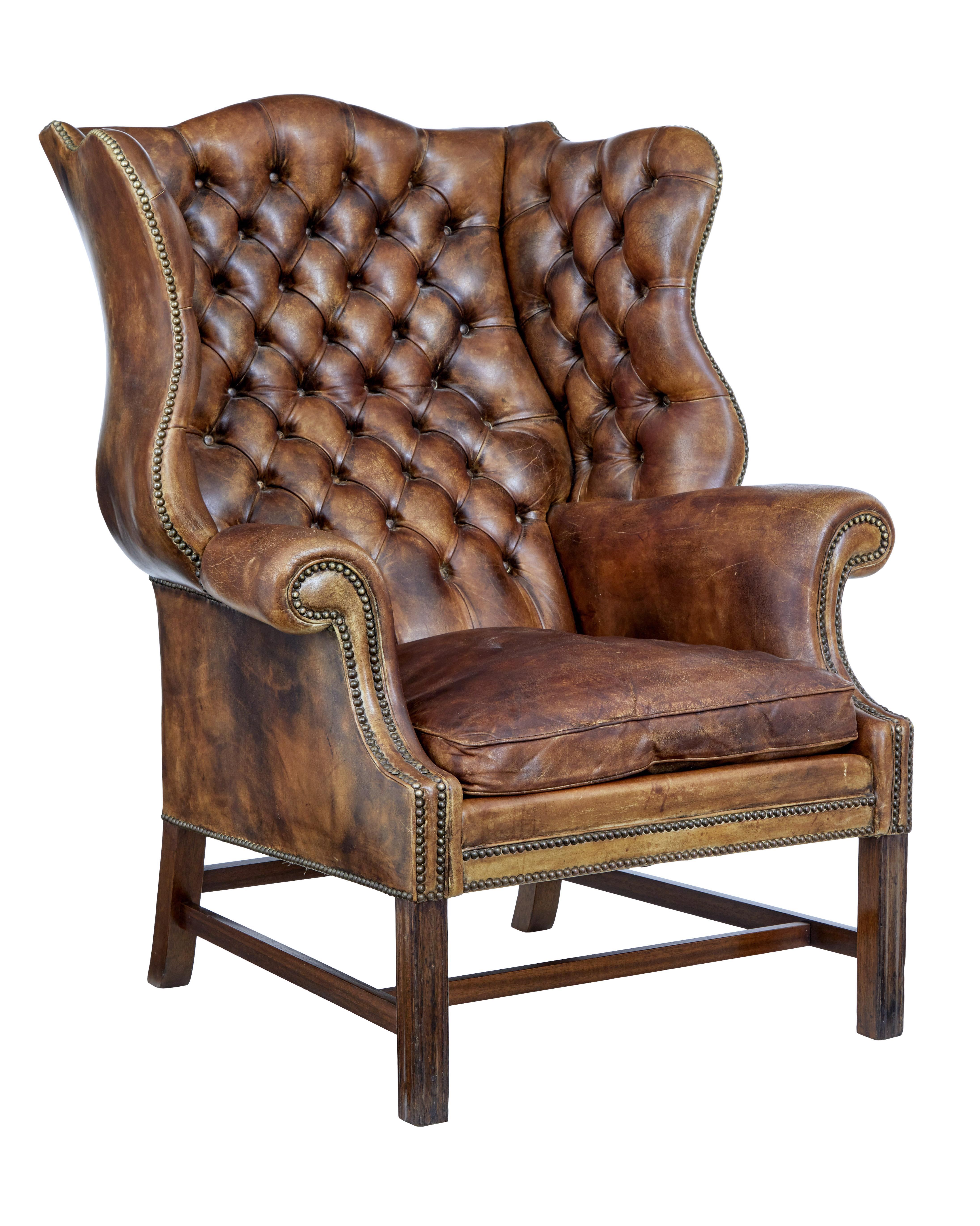 Early 20th century Edwardian button back leather wing back armchair circa 1905.

Substantial piece of opulent comfort from the early 20th century. Beautifully upholstered in brown leather. Shaped back with deep wing back head rests. Decorated with