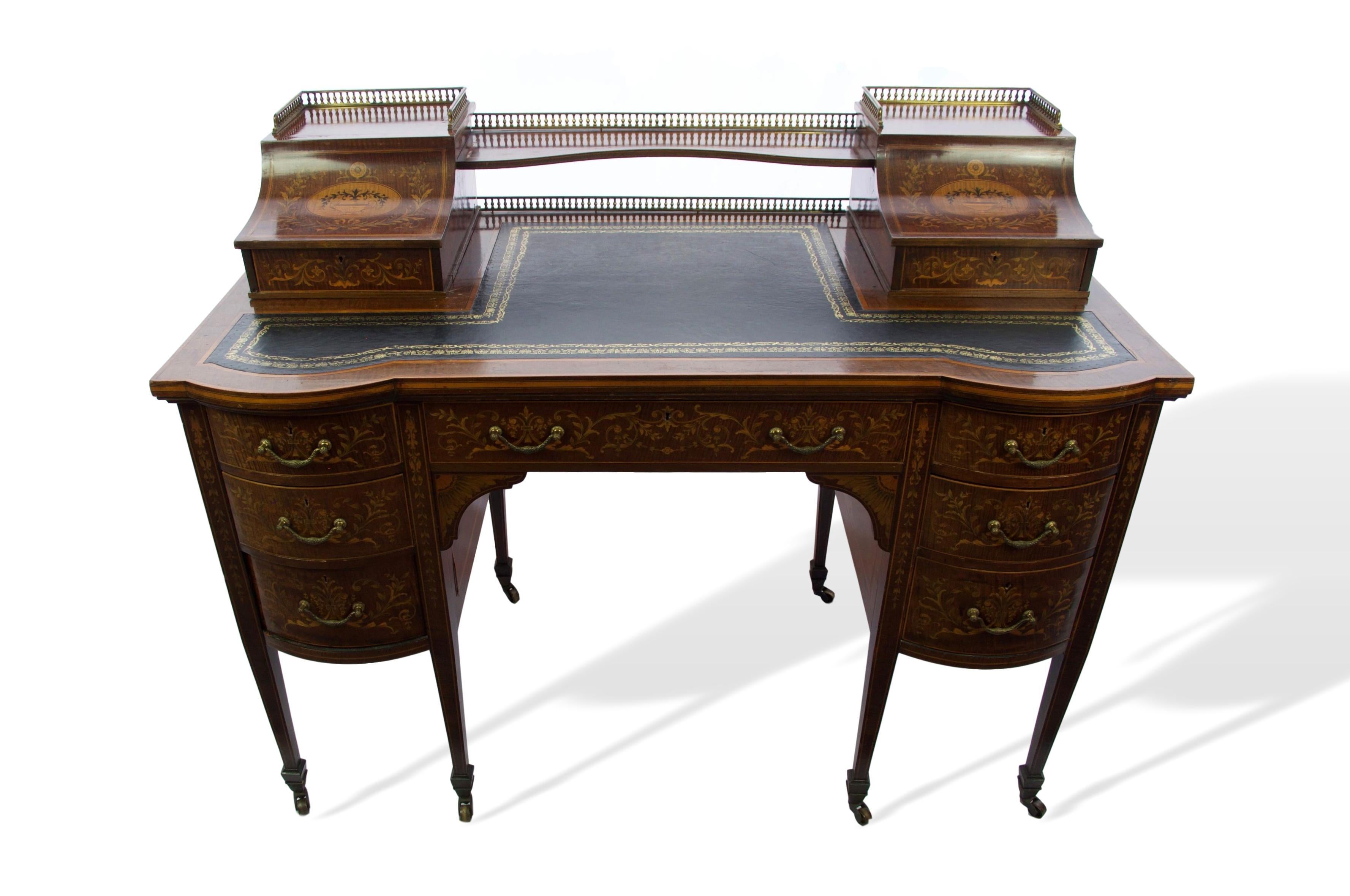 This early 20th century Edwardian mahogany Edwards and Roberts Carlton desk feature a bow-front with Italianate marquetry and bronze ormolu handles and gallery.