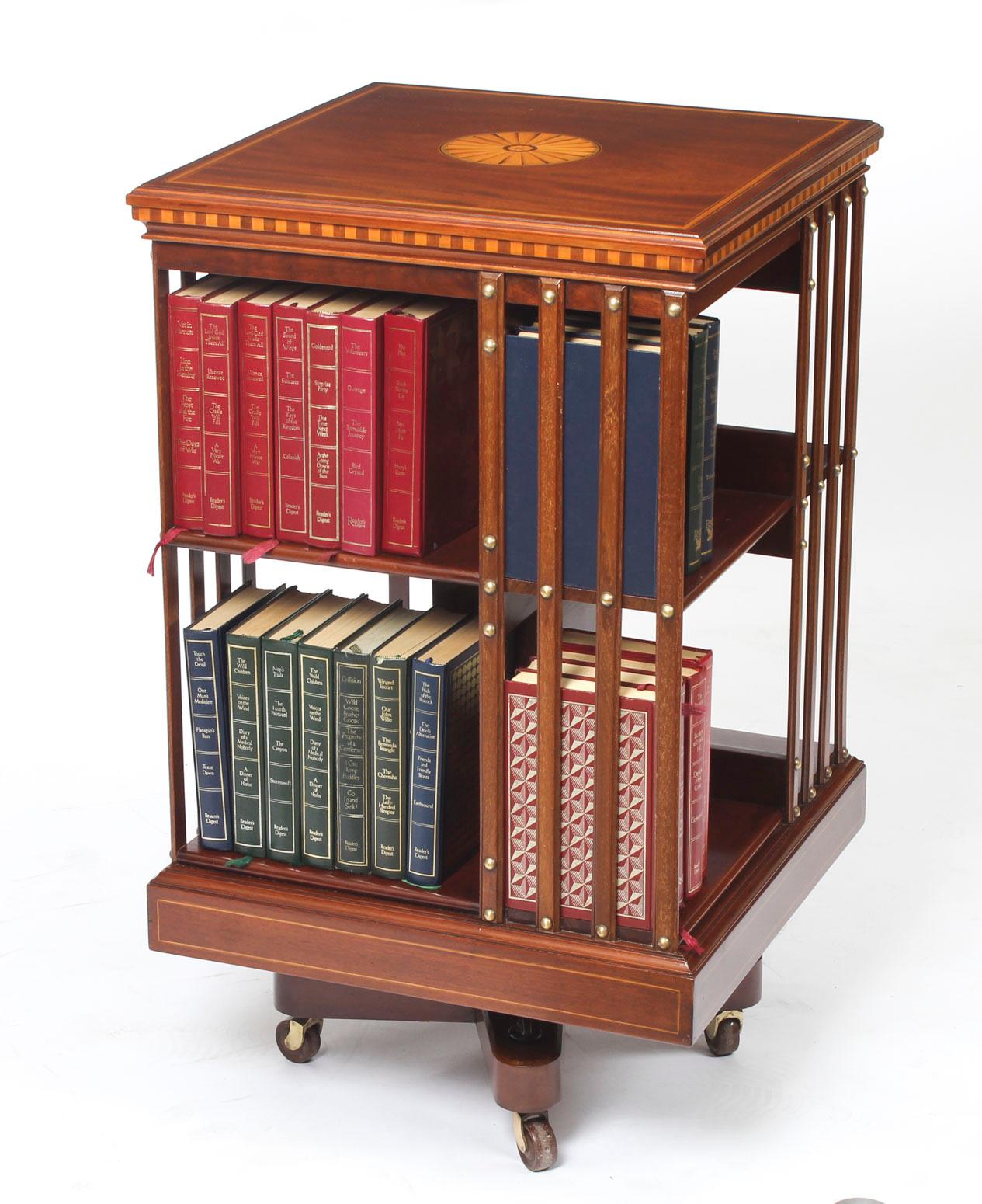 This an exquisite antique revolving bookcase by the renowned Victorian retailer and manufacturer Maple & Co., circa 1900.

It is made of mahogany , revolves on a solid cast iron base, has inlaid boxwood lines to the top and bottom, the top with