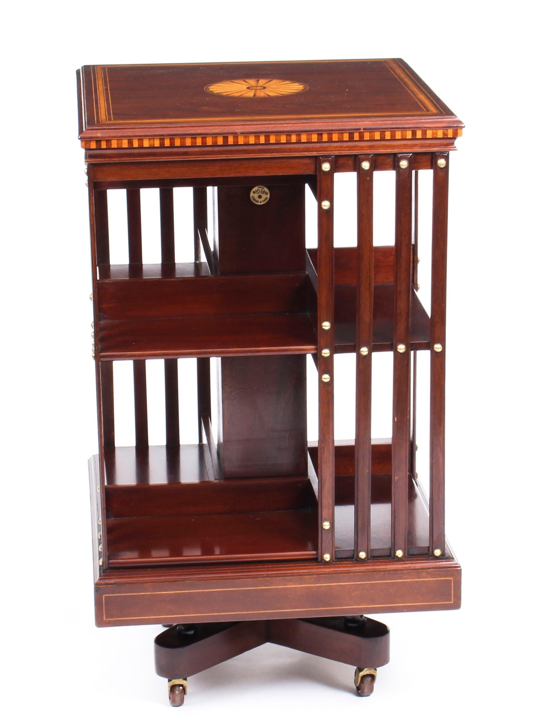 This an exquisite antique revolving bookcase by the renowned Victorian retailer and manufacturer Maple & Co., circa 1900.

It is made of mahogany, revolves on a solid cast iron base, has inlaid boxwood lines to the top and bottom, the top with has