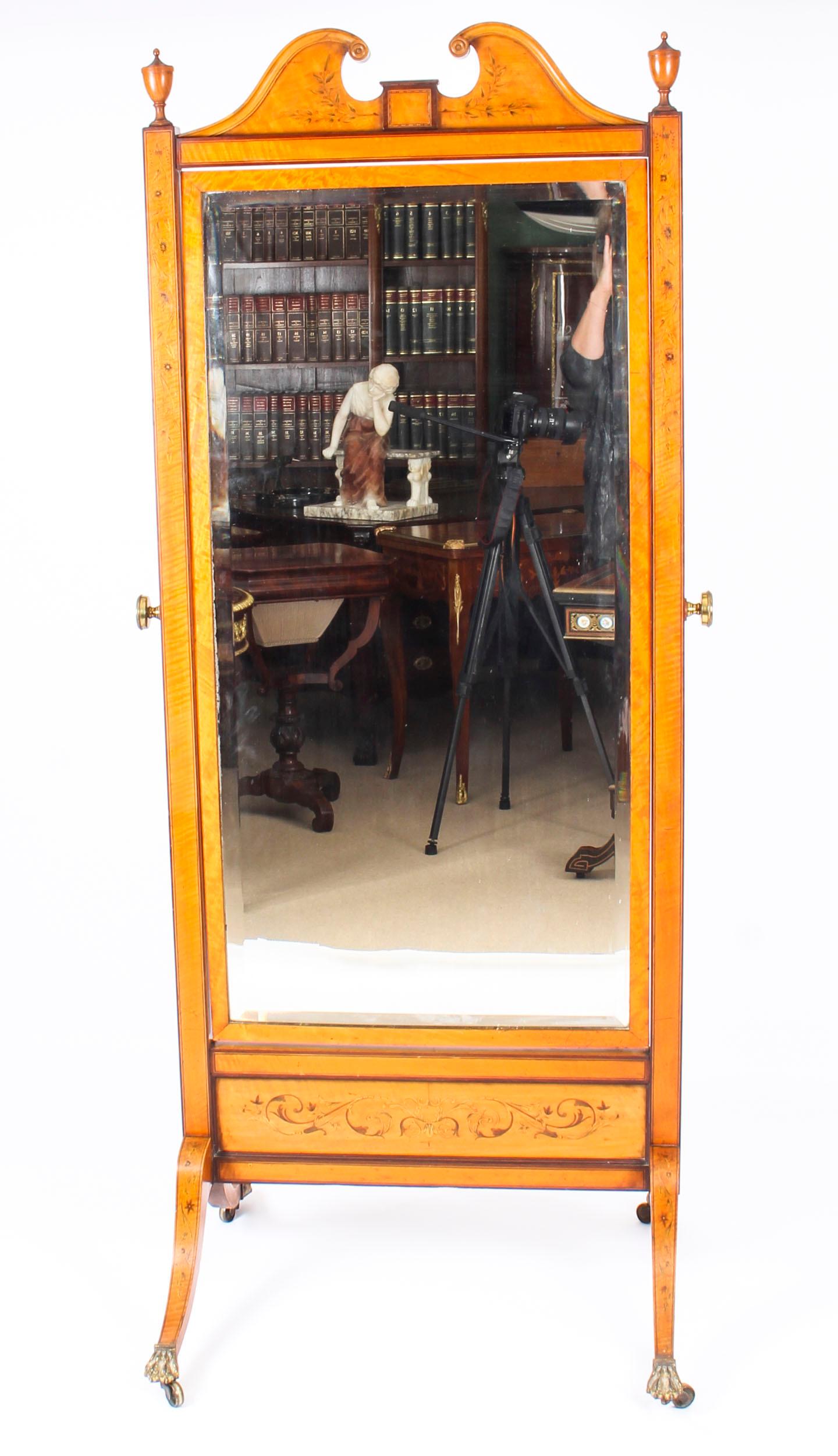 A stunning quality English satinwood and inlaid Edwardian period antique cheval dressing mirror, circa 1900 in date.

The central rectangular mirror plate is shaped with a bevelled edge. It features a swan neck pediment flanked by urn finials and is