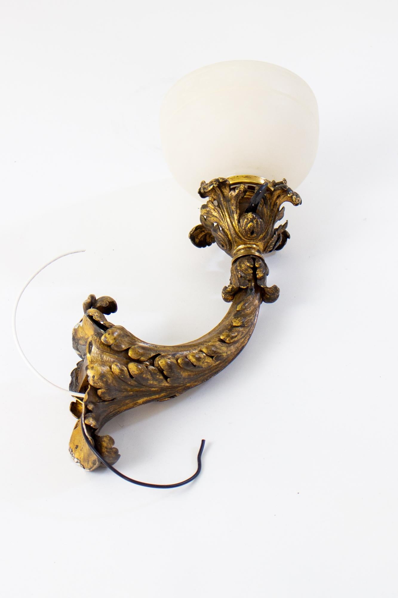 Early 20th Century E.F.Caldwell Gilt Leafy Sconces with Alabaster Shade, a pair. Intensely Leafy cast gilt bronze sconce brackets, designed with an integrated narrow backplate. The arm of the sconce curves up to a matching leafy socket cover. Cup