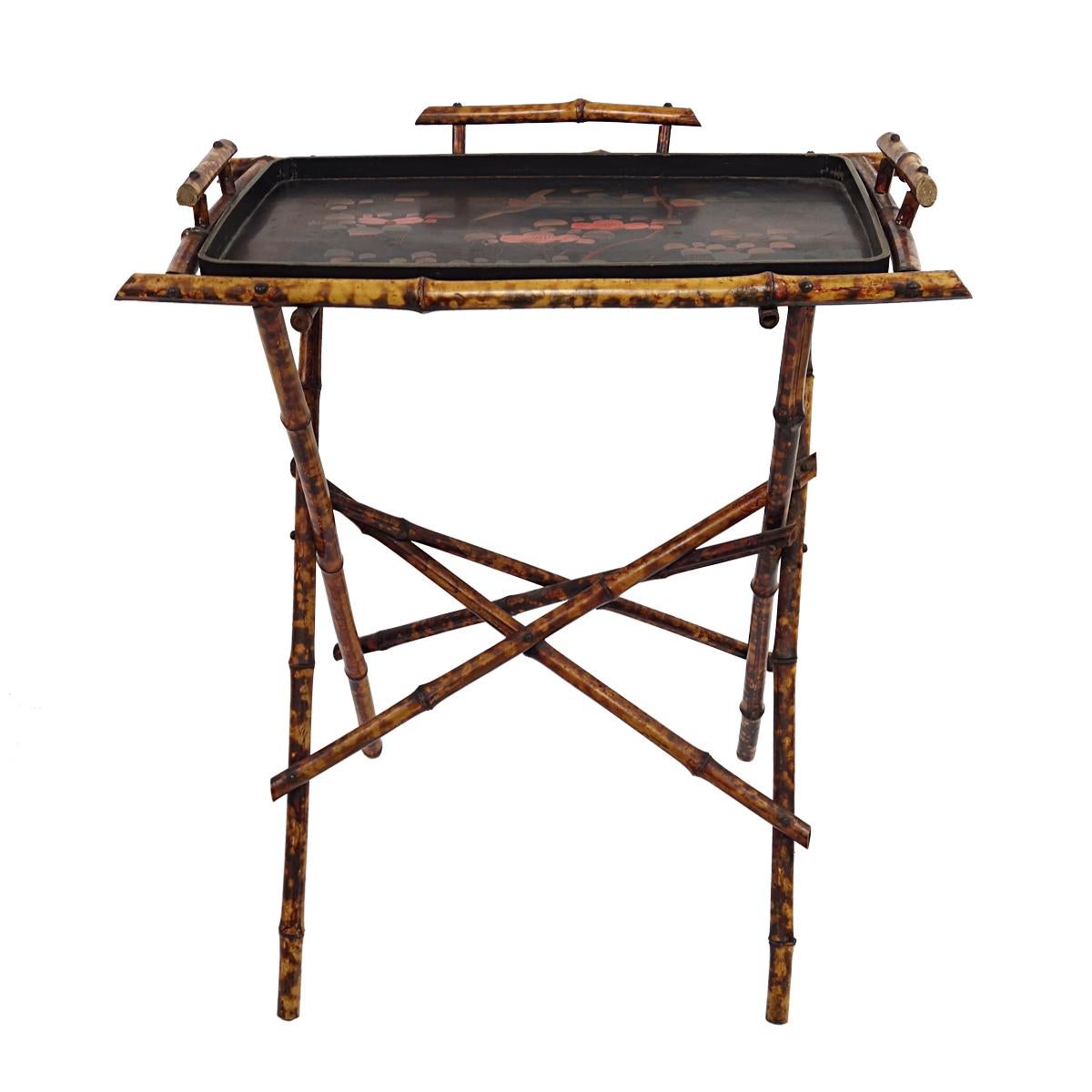 Very refined tray table with removable tray with oriental origins, probably from 1920s China.

The frame looks pleasantly fragile and is made of bamboo. The tray is made of lacquered wood and has been decorated with flowers and a bird.

A very