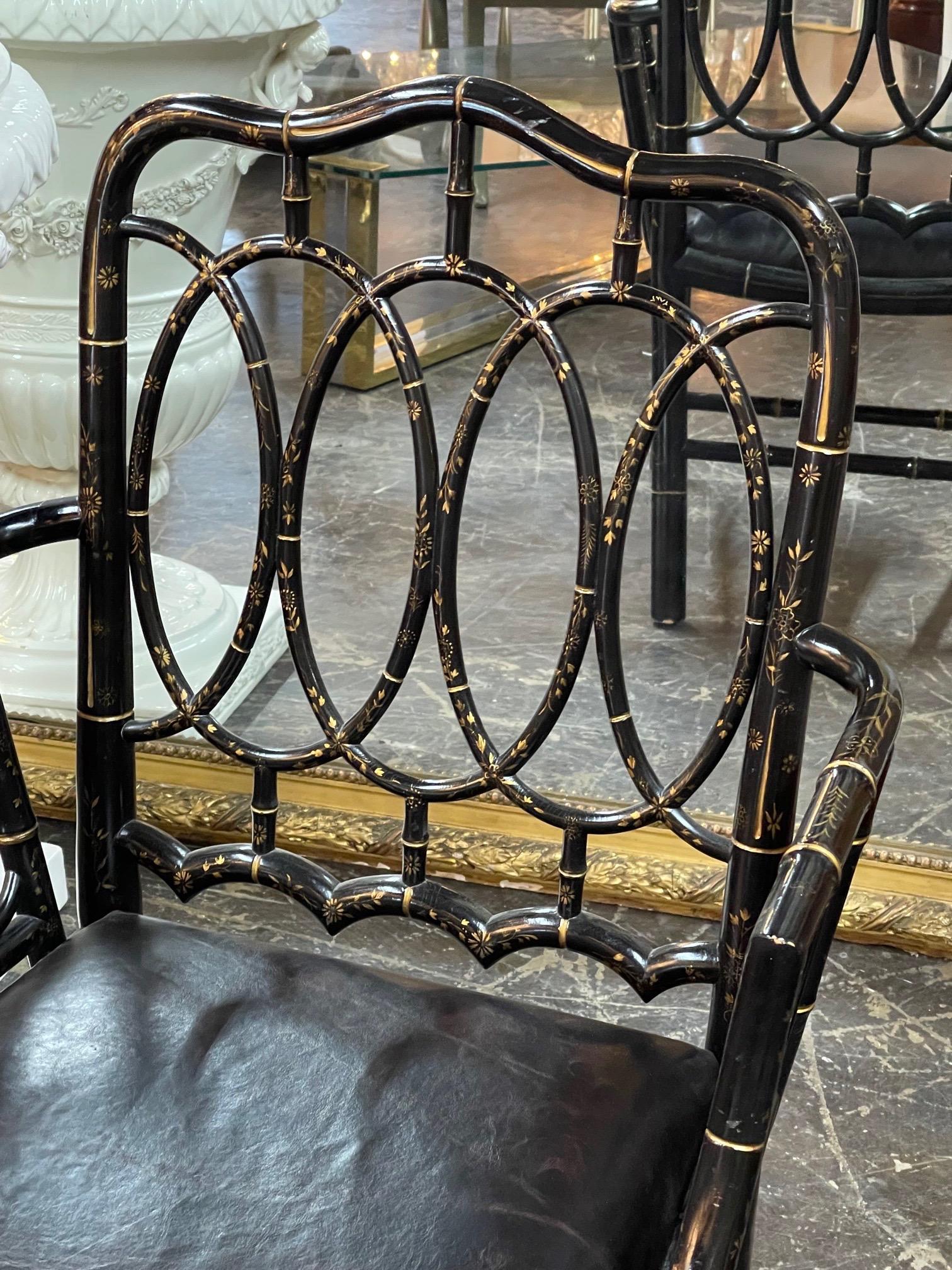 Handsome early 20th century English bamboo black lacquered chair. The piece has a pretty hand-painted design in gold and is upholstered in black leather. So pretty!!