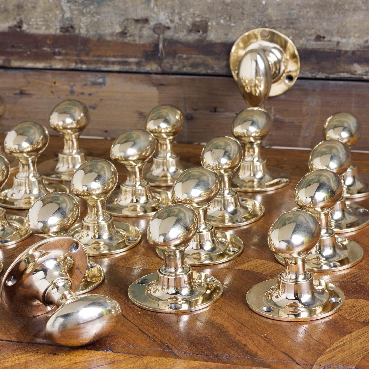 Early 20th century oval door knobs, circa 1900 manufactured by 'Kaye of Leeds', cast in rose brass with tapered collars and circular backplates. Sold as pairs, spindles included.