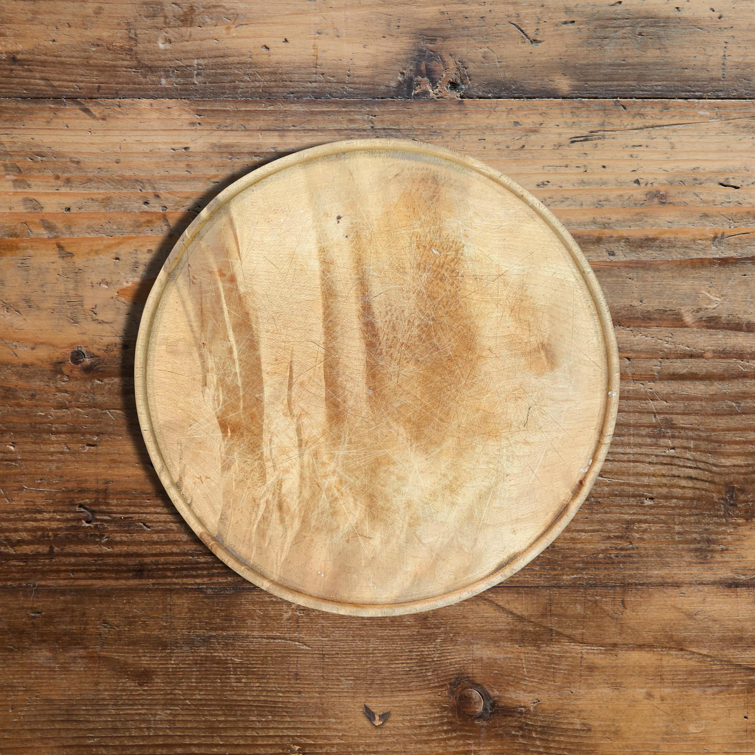 A wonderful early 20th century English sycamore breadboard of simple form with a slight lip around the edge. Not only perfect for serving bread, but makes an excellent charcuterie and cheese board!