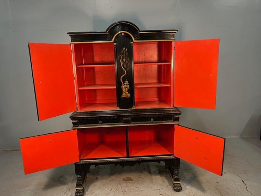 Questo mobile inglese di epoca edoardiana con finitura laccata nera con decorazioni dorate in rilievo e interni rossi è stato probabilmente realizzato come credenza per una sala da pranzo, ma potrebbe essere utilizzato come contenitore di vario