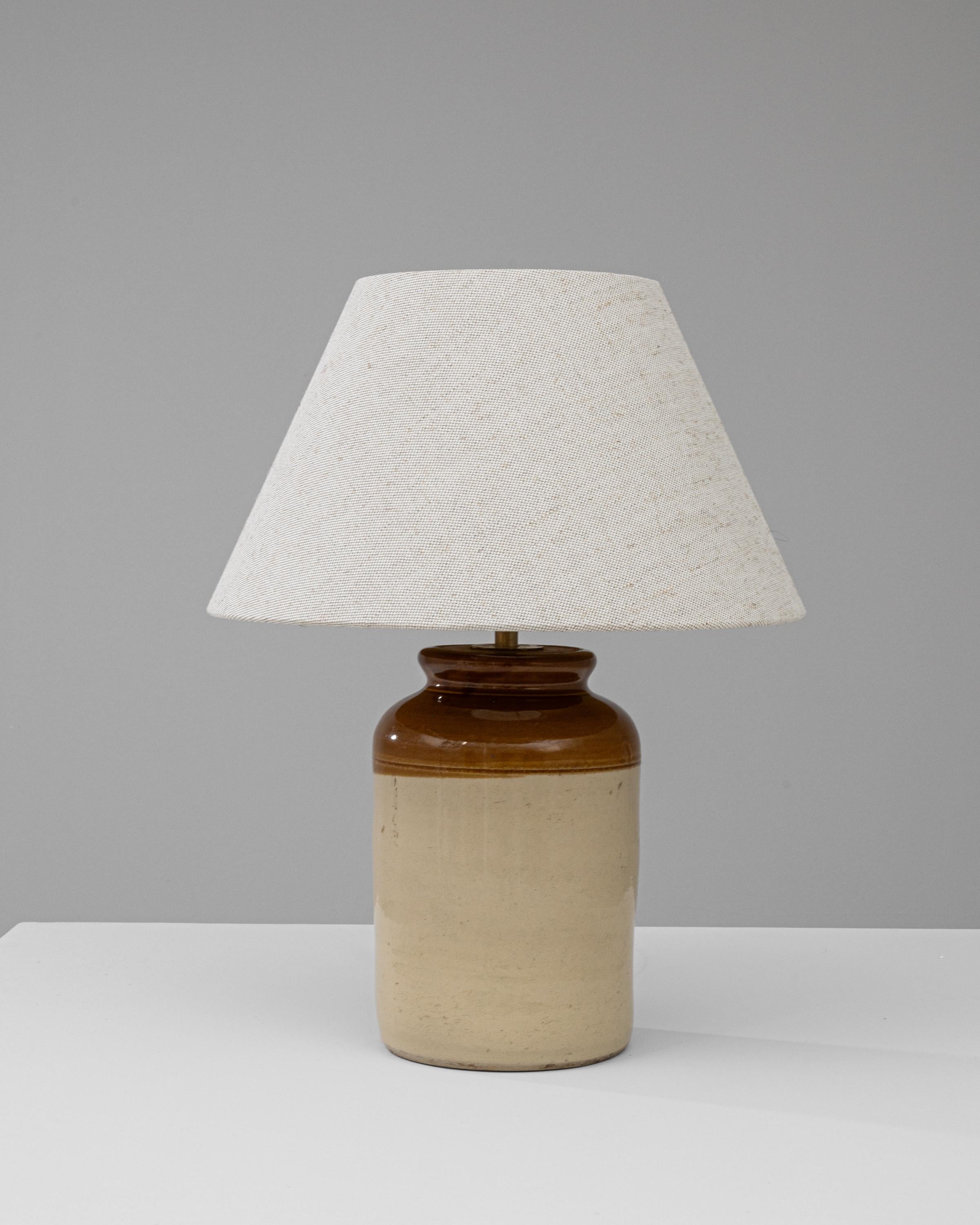 Discover the charm of the past with this Early 20th Century British Ceramic Table Lamp. Crafted with the finesse of yesteryear's artisans, this lamp boasts a sturdy, two-tone ceramic base that evokes the rich, earthen tones of the English
