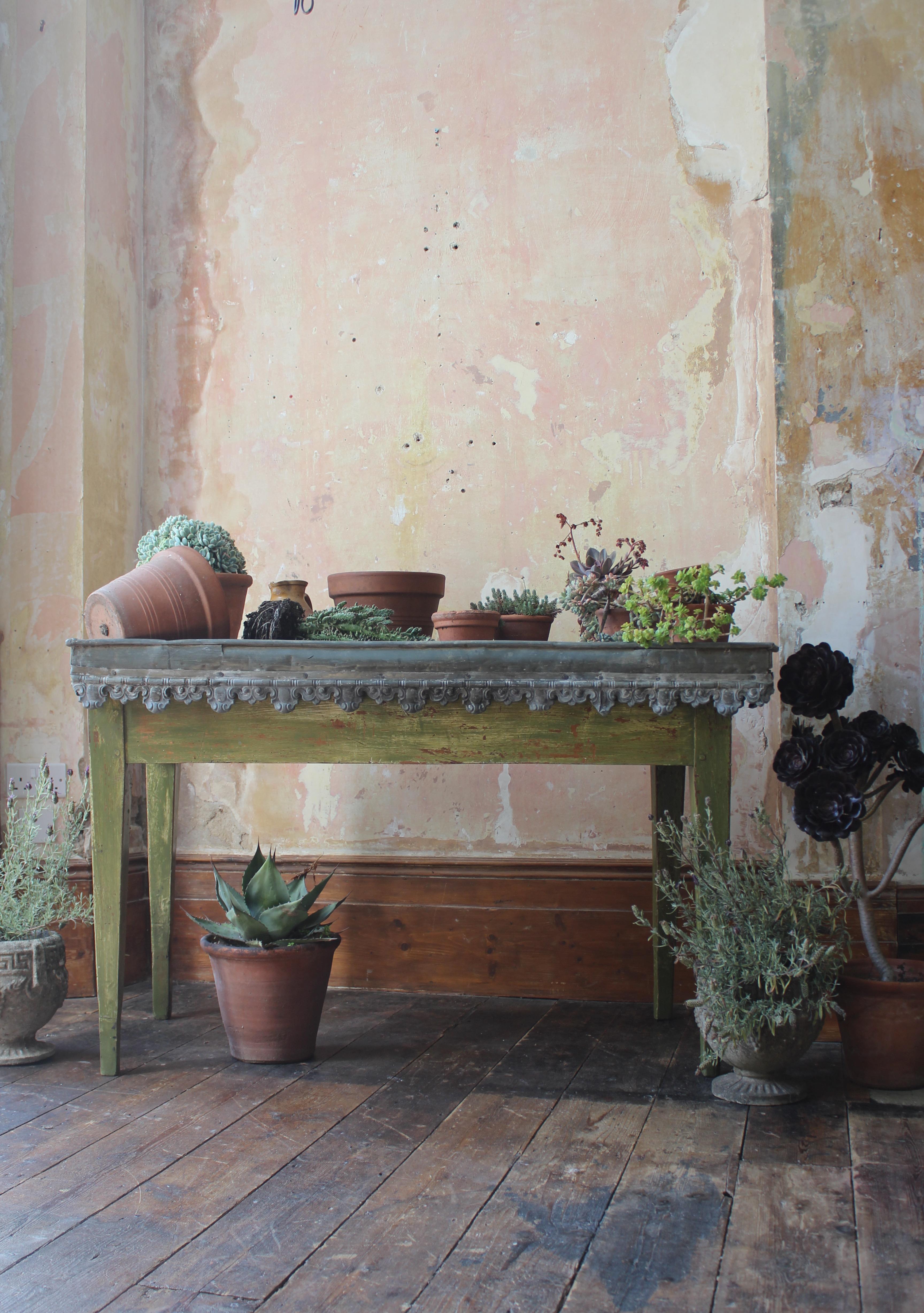 An attractive orangery potting table, with a pressed decorative zinc frieze. The internal trough is covered again with zinc and terminates over the lip of the table top to give a water tight working area. The original drainage hole and spout are