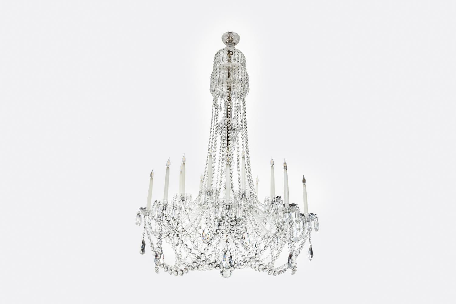 Exceptionally large, early 20th century English crystal chandelier. The central baluster stem having bowl hung with long swags of faceted drops to catch the light. The middle cut glass bowl has eighteen curved candle arms with large glass drops,