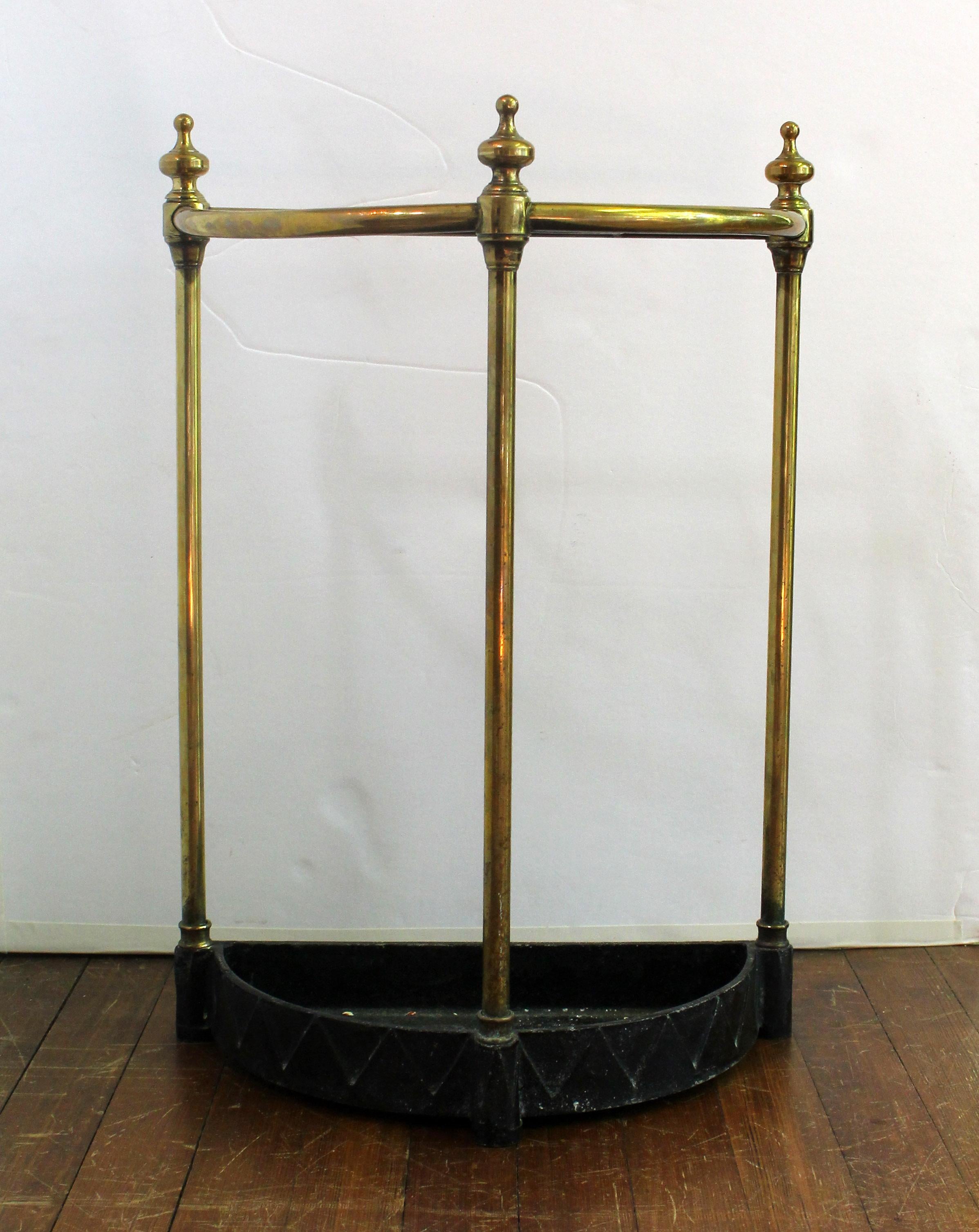 Early 20th century brass & zinc demilune form stick stand, English. Of good weight with well turned finial tips. Marked: JANS; #226, Made in England. 16