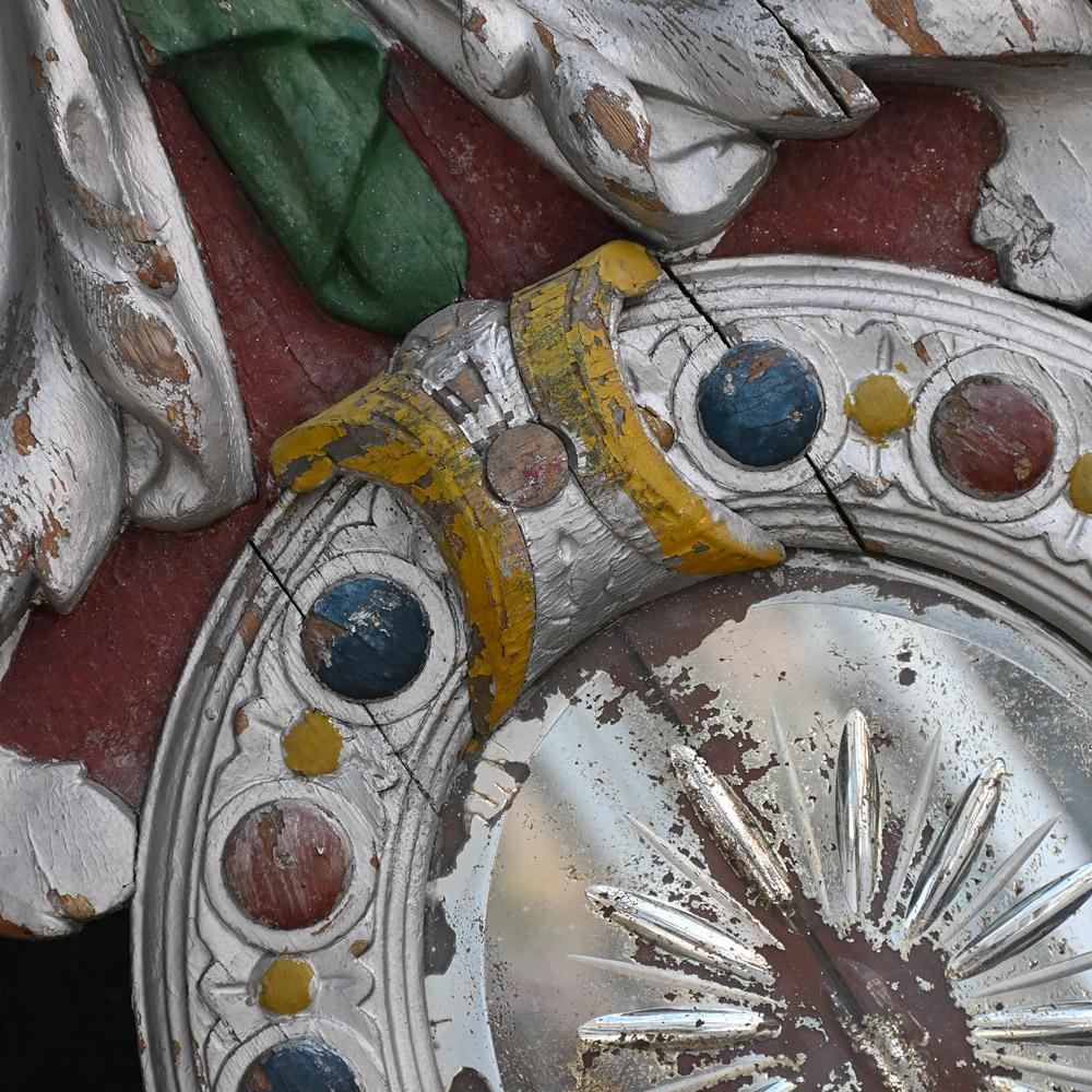 Frammento centrale di giostra da fiera inglese dell'inizio del XX secolo 

Un esempio intagliato a mano di pannello centrale a specchio di una giostra da fiera, vivace e altamente decorativo. Con lo specchio originale ancora al suo posto, con le