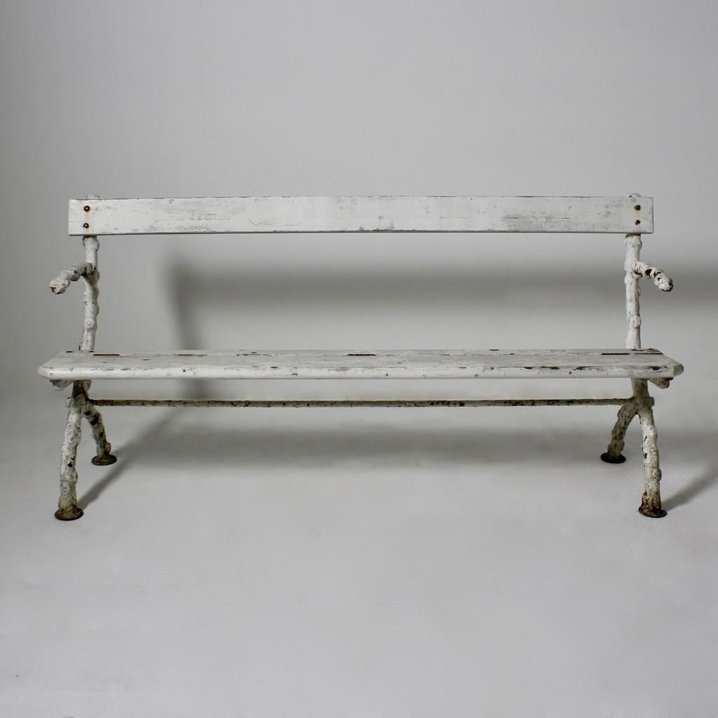 A wonderfully decorative, early 20th century faux bois cast iron and pine garden bench. Retaimg many layers of ancient paint, all beautifully weathered and worn.

English, circa 1920.