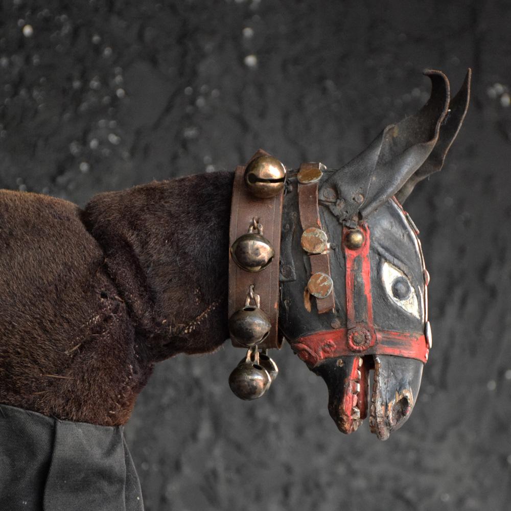 An unusual and highly decorative example of an early 20th century horse puppet, a carved wooden head with leather detail across most of the item. Aged leather bell strapped neck collar still intact. The body is made from a hand carved section wooden