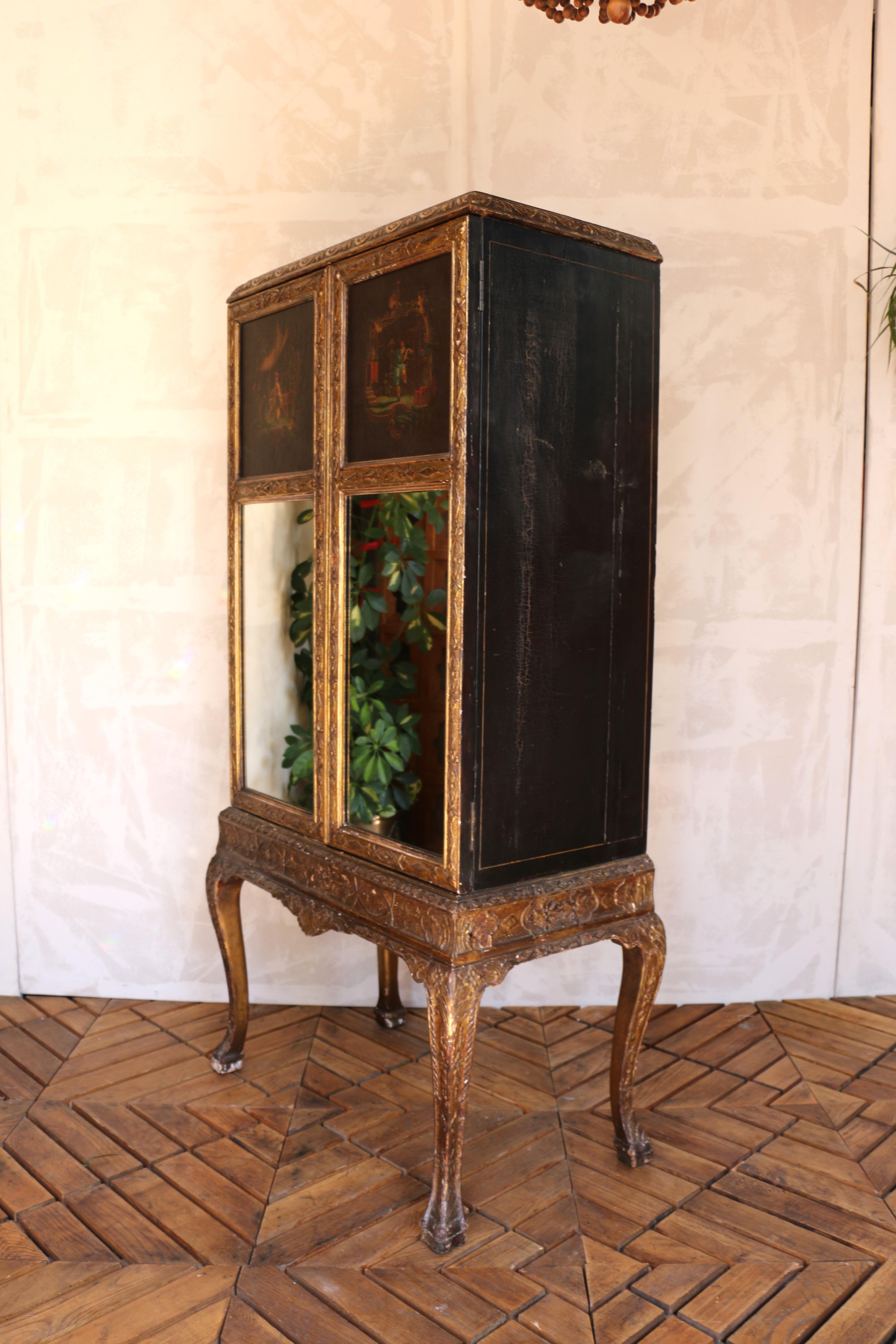 Un notevole mobile inglese dei primi del Novecento che mostra un'arte raffinata e un'eleganza senza tempo. Le doppie porte sono caratterizzate da squisiti pannelli scenici dipinti a mano su tela sopra inserti a specchio, creando un accattivante