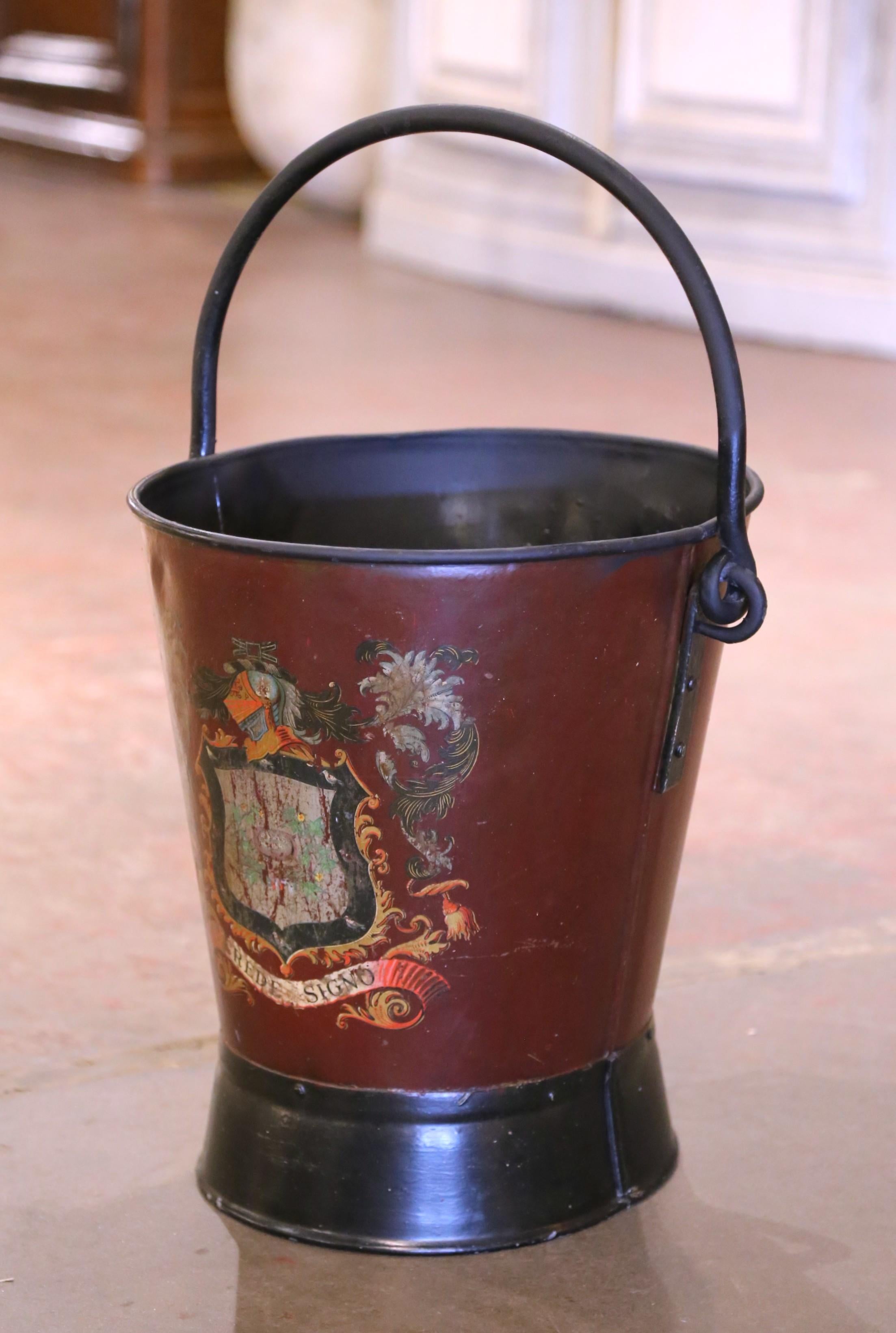 Place this large, colorful antique stand at your front door or in your mudroom to collect umbrellas, canes or other accessories. Created in England, circa 1930, the burgundy iron bucket with top and back handle features a beautifully painted family