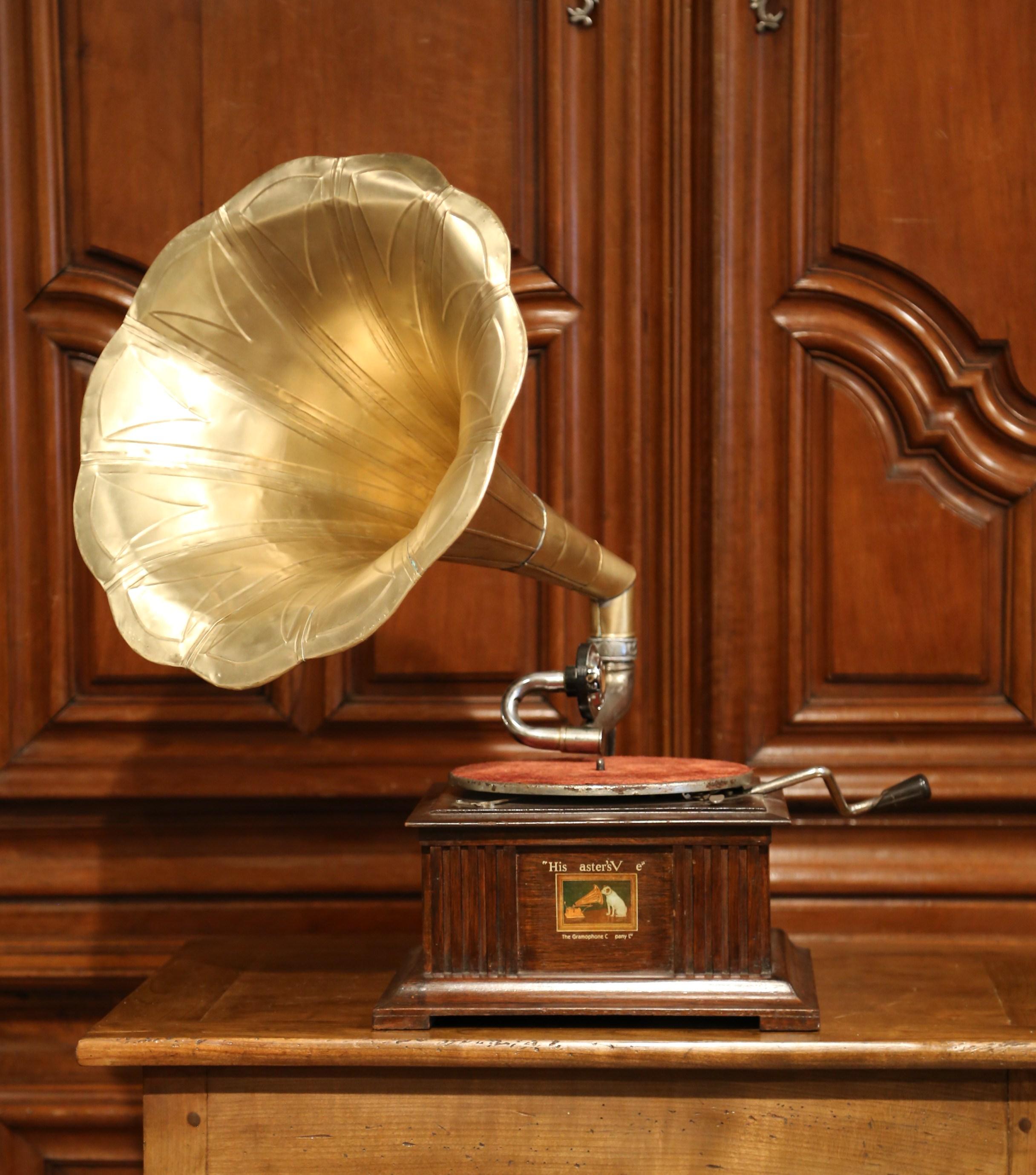 Place this antique gramophone in your study or game room; crafted in England circa 1910, the music box example bears the trademark His Master's Voice decal with Nipper the dog and a detached fluted brass horn. The cast metal horn bracket features a