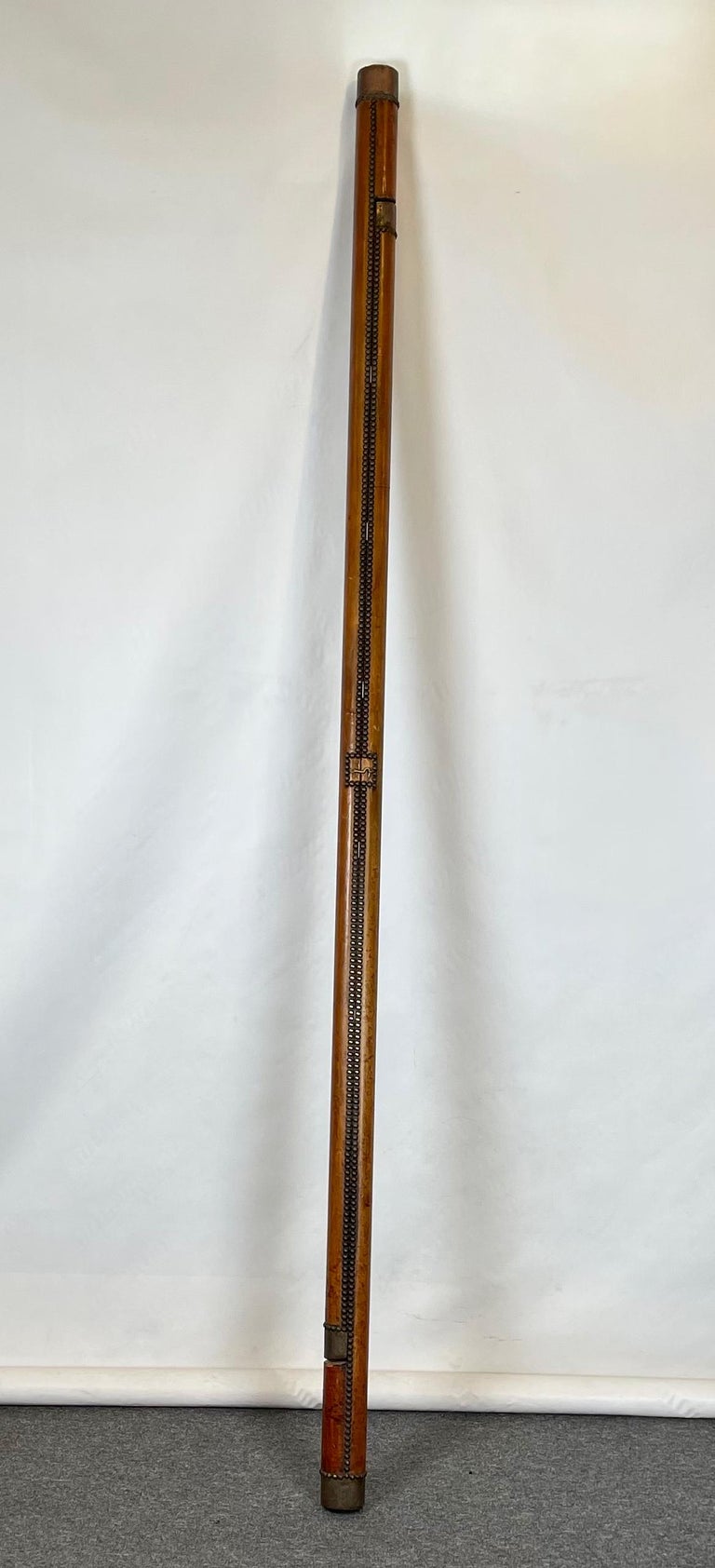 An English Edwardian folding mahogany pole ladder in deep brown leather and brass nailheads opening to seven rungs.