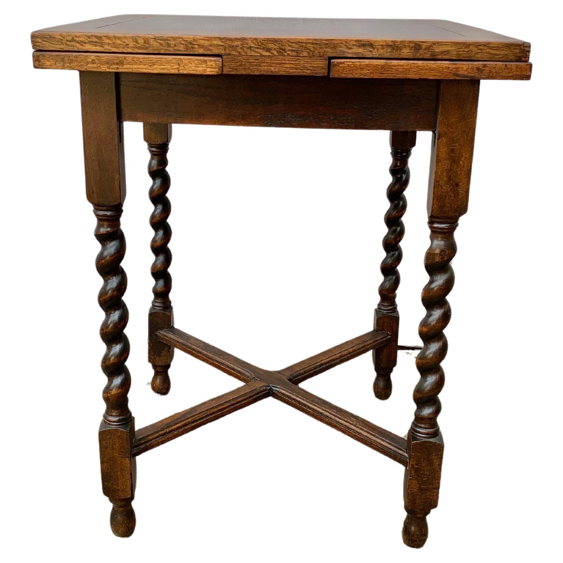 Found in England, this Early 20th Century Side Table was handcrafted by English furniture artisans from old growth oak in the early 1900's. The piece features a square top and two leaves that are paneled. Each leaf is secured in place in the