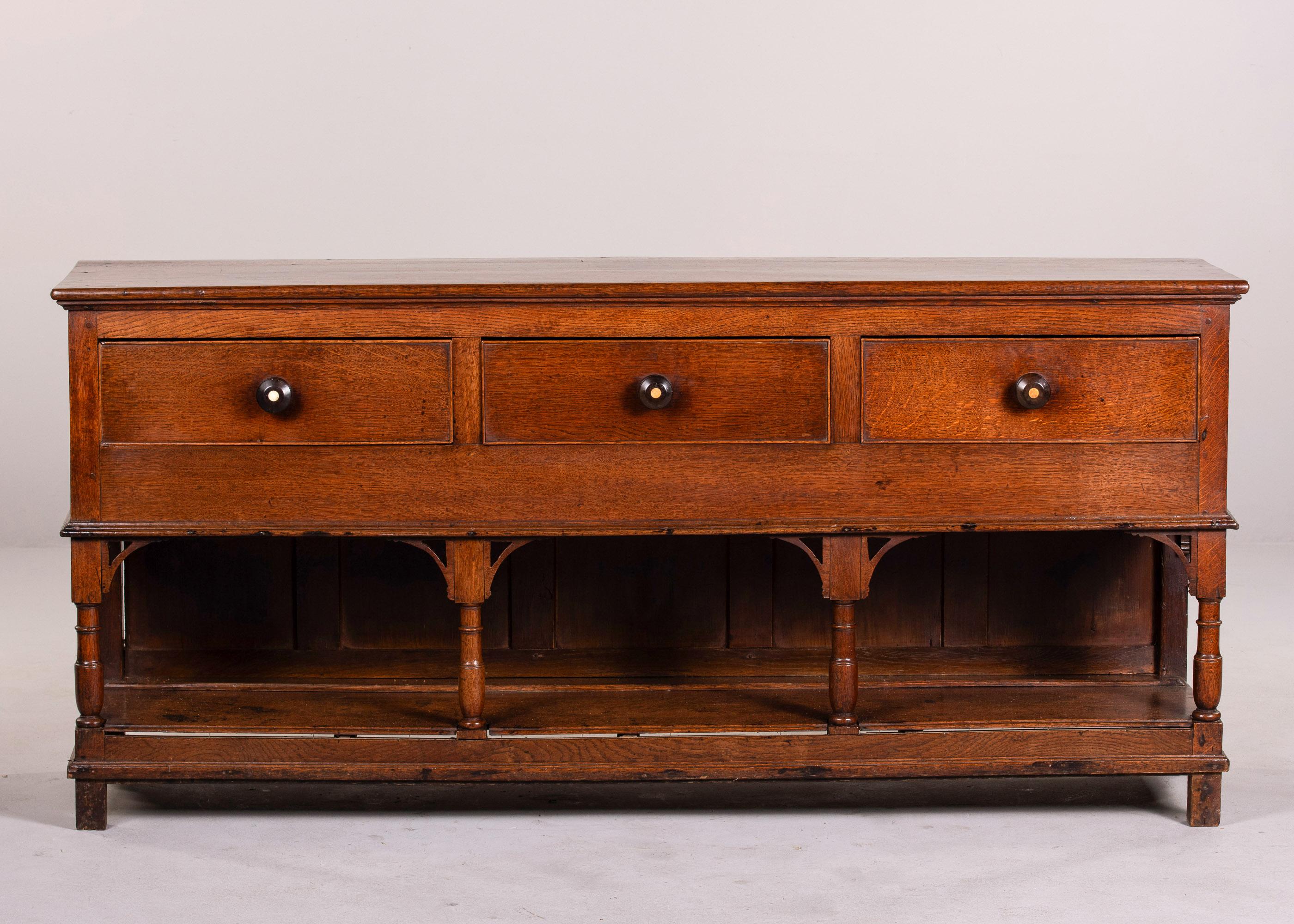 Found in England, this large oak dresser base dates from approximately 1905. The base makes a great console, server or table for a foyer. Dresser features four turned legs and a low base shelf with three functional drawer. Original knobs on drawer