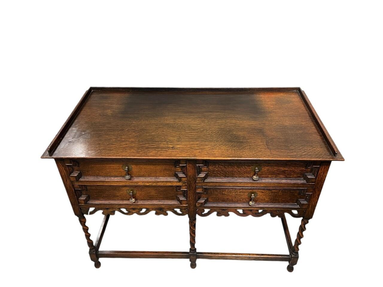 Classic Jacobean style with four geometric paneled drawers and original brass drop drawer pulls with a full-length carved apron below.
All four legs (front and back, always a sign of quality) are English barley twist.
Some discoloration on top as