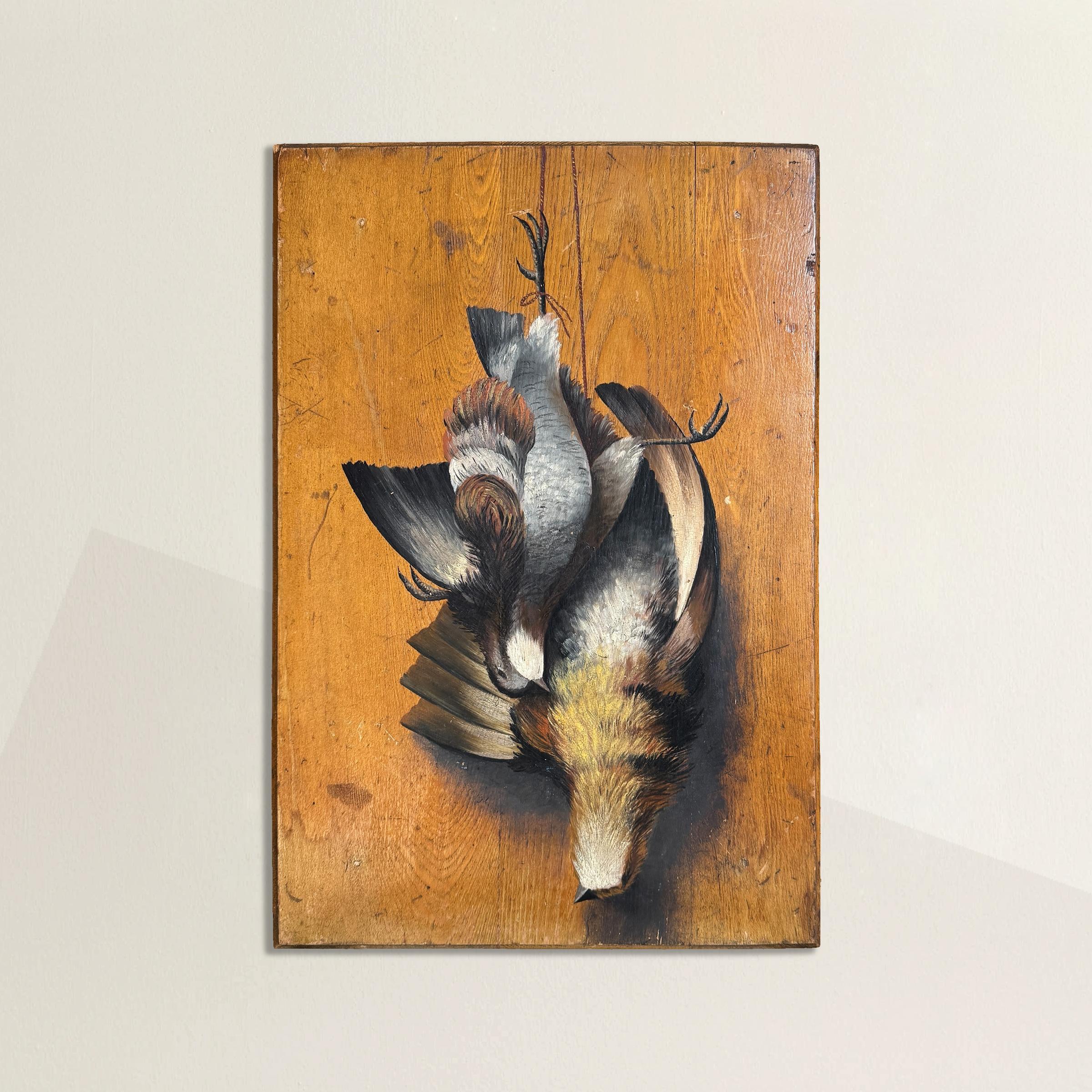 An evocative early 20th-century English oil on board, this hunt trophy painting depicts a brace of partridges suspended from a lanyard against a rich wood-paneled backdrop. The artist’s keen attention to detail captures the birds’ delicate plumage,