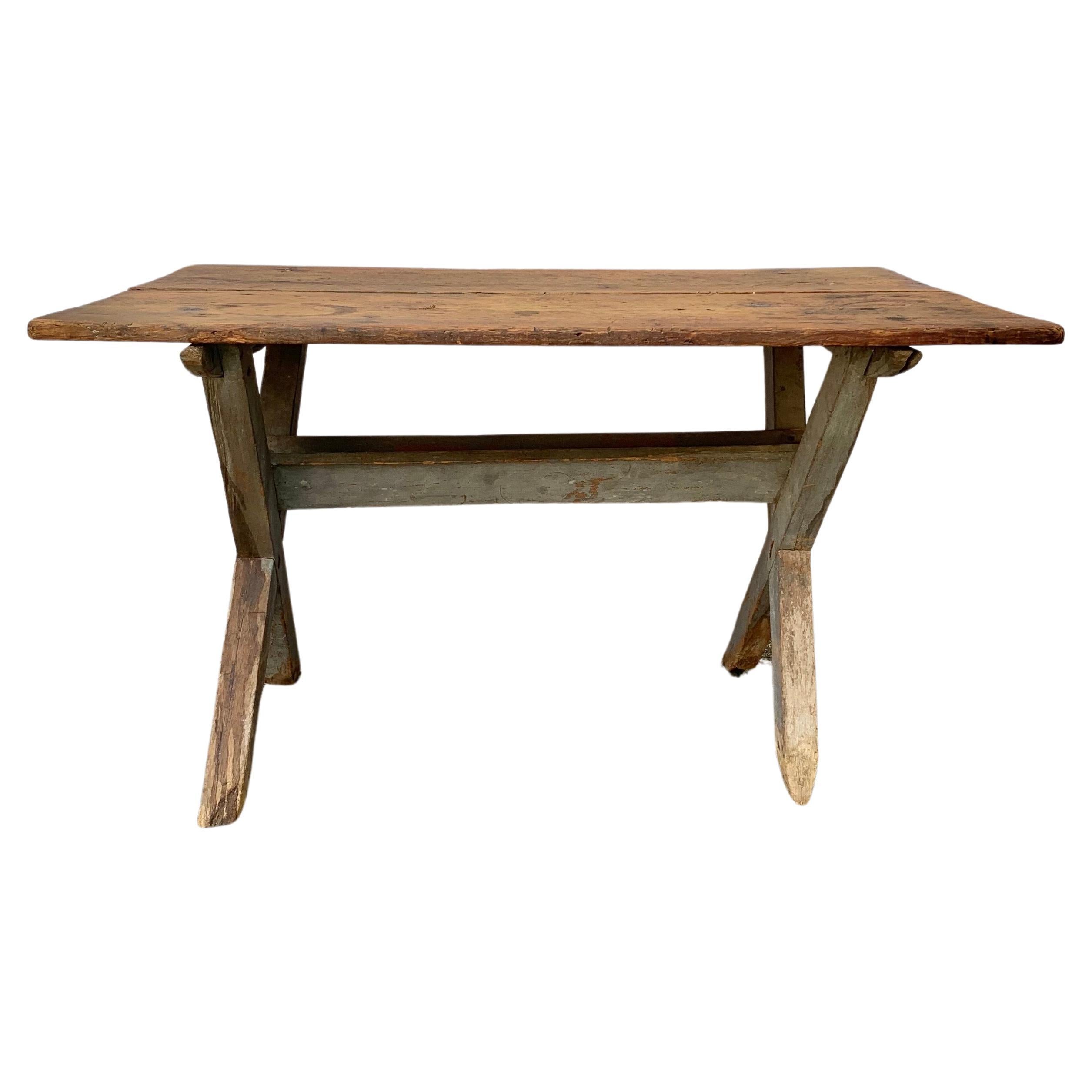Found in the English countryside this Early 20th Century English Sawbuck Side Table was hand crafted by furniture artisans from old growth English Pine. This table features a two plank rectangular top sitting above a patinated simple X-form base