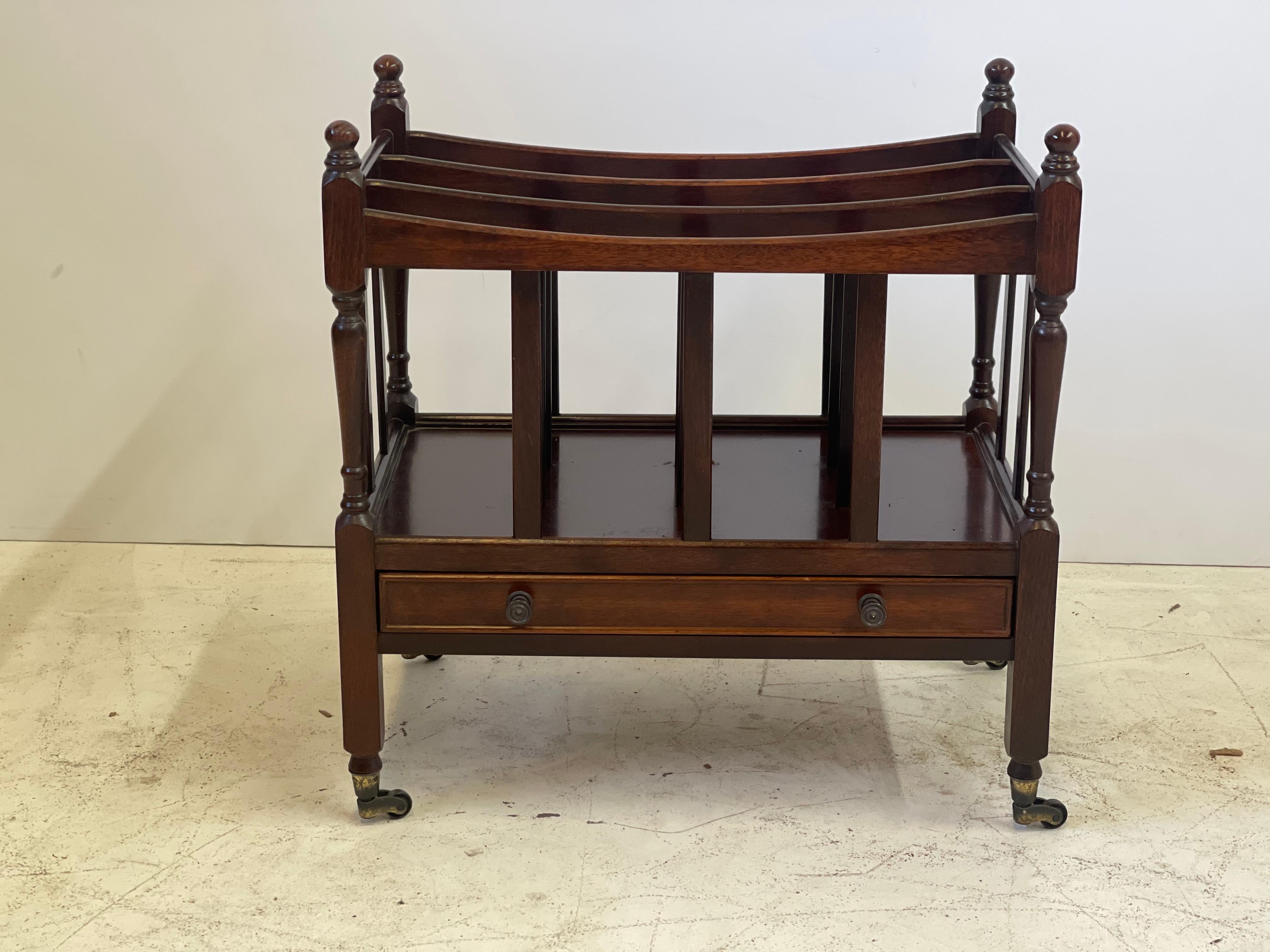 Early 20th century English Canterbury of mahogany designed in the Regency style with three divided compartments for music or magazines, beautifully turned uprights on each corner, and a drawer in its frieze. The table is raised on block feet and