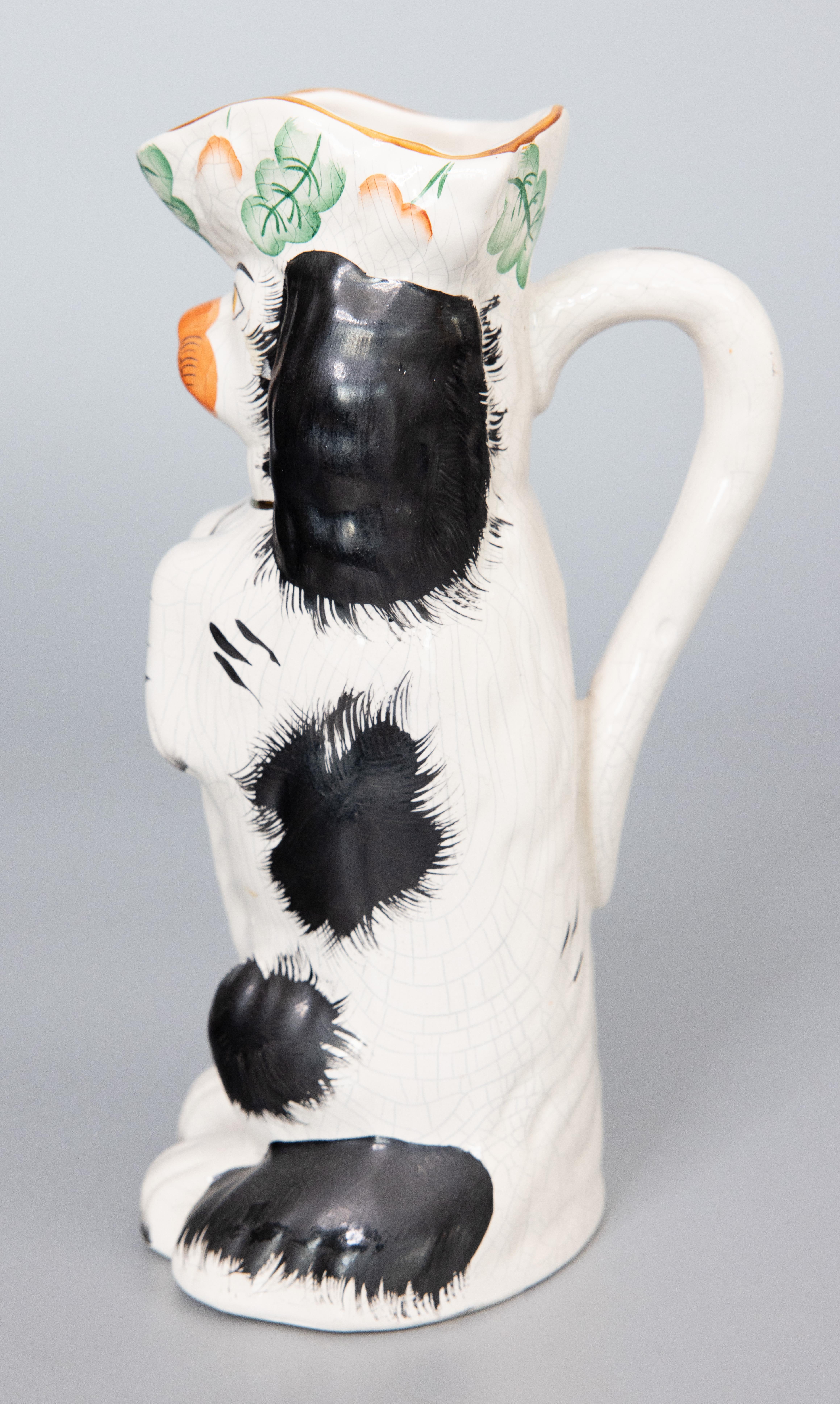 A superb early 20th Century English Staffordshire black and white Spaniel dog pitcher. This charming dog is hand painted with fine details and the sweetest expression. It's hard not to be smitten! It would be wonderful displayed and would be perfect