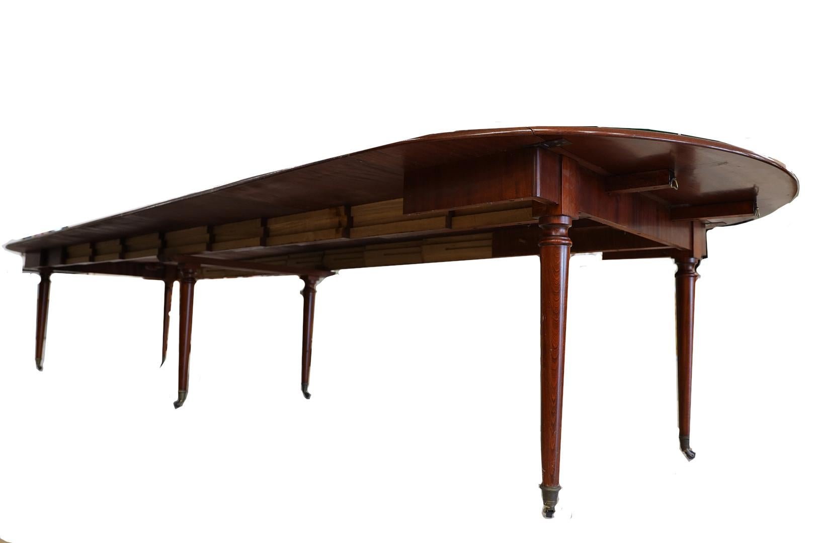 An English George the II styled dining table with oval drop leaf ends supported by slides and five 24