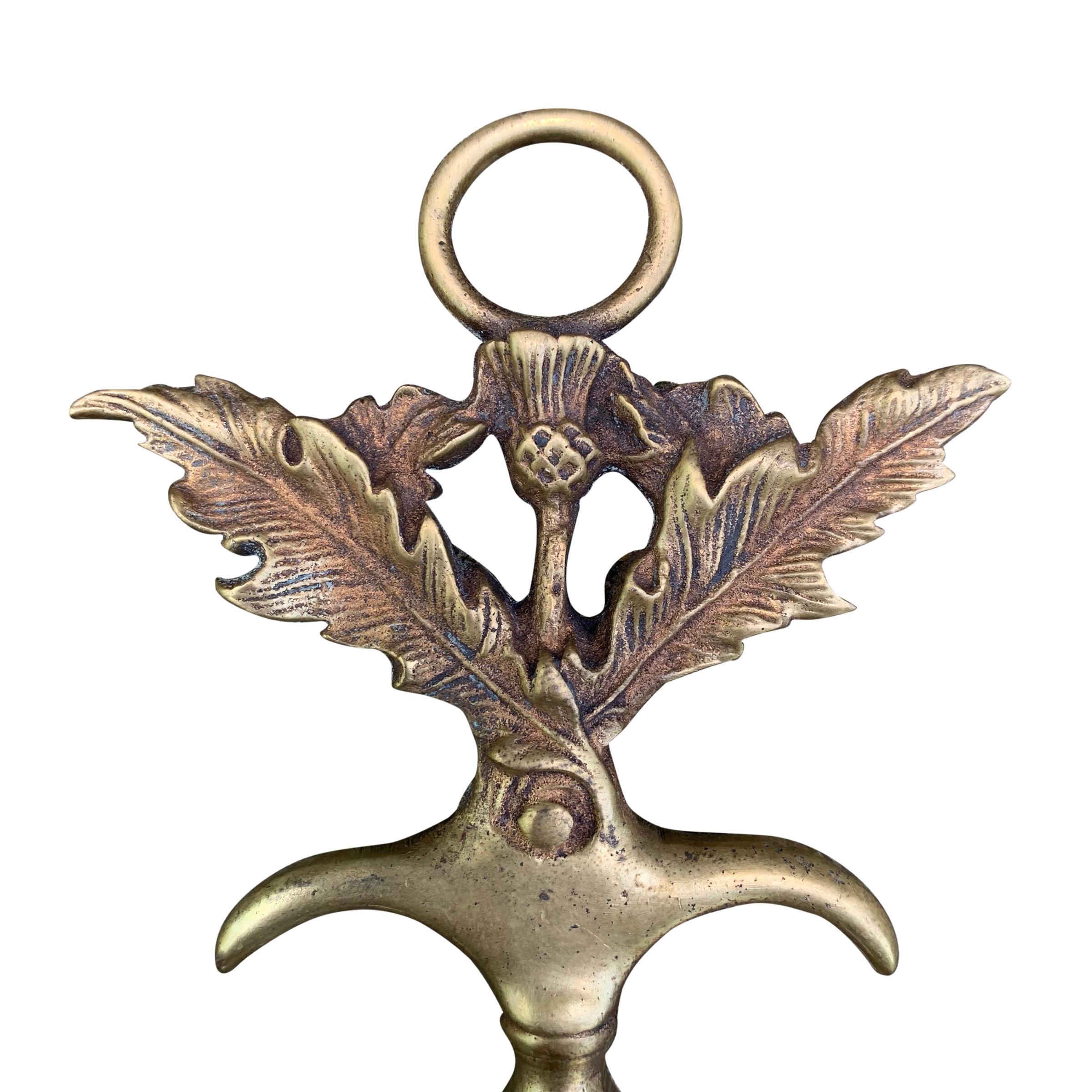 An early 20th century English cast brass corkscrew with a loop and two hooks help to pop the cork, and a Scottish thistle motif.