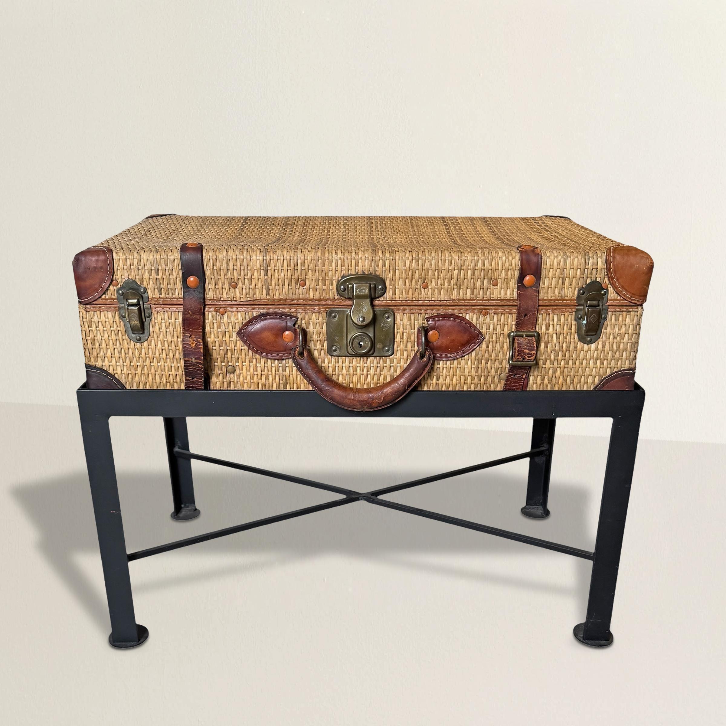 A knockout of a trunk-turned-table, this early 20th-century English suitcase is pure Edwardian-era charm, embodying the refined yet adventurous spirit of the time. Woven wicker wraps the entire body, warm and textured, while leather strapping and