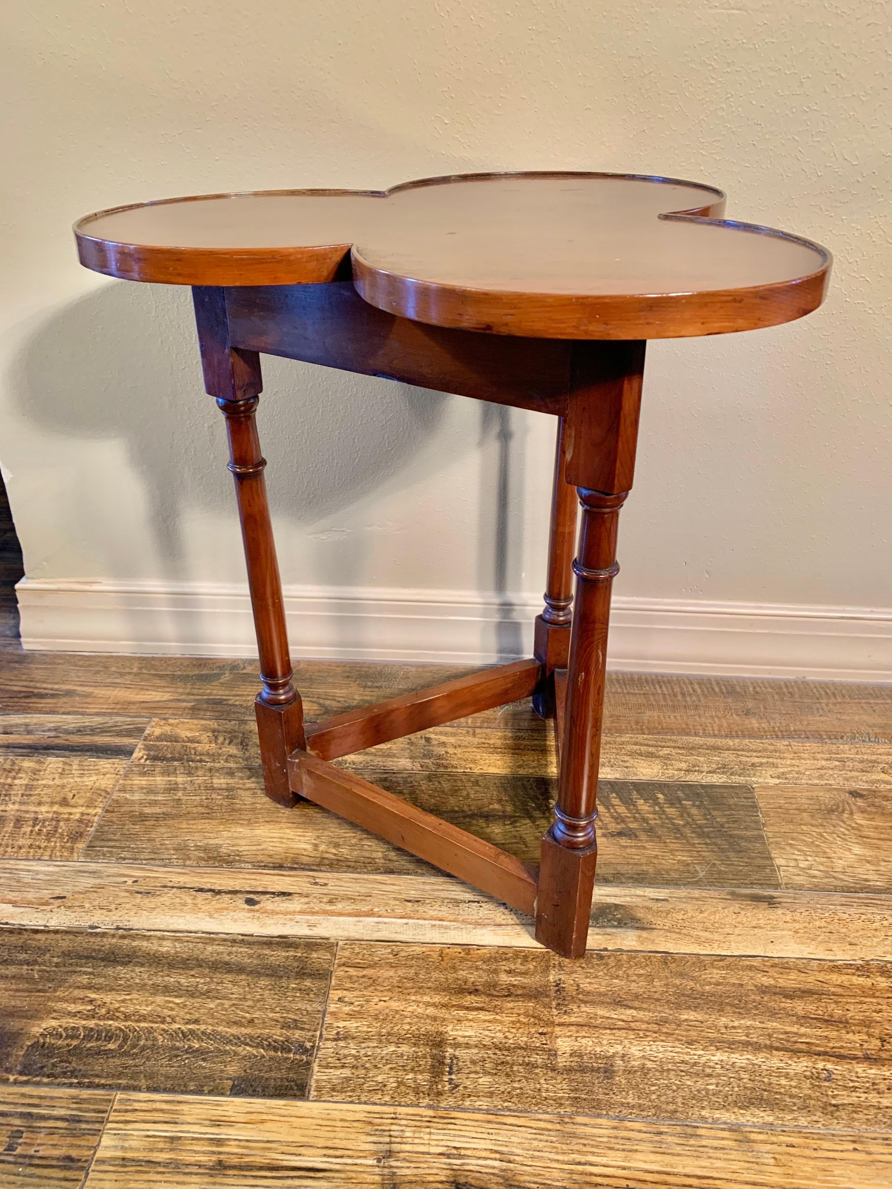 Found in England, this Cricket Clover Side Table was crafted by English artisans from old growth walnut in the early 20th Century. The table features a trefoil clover shaped top resting above a triangular frieze and Cricket base. Each of the three