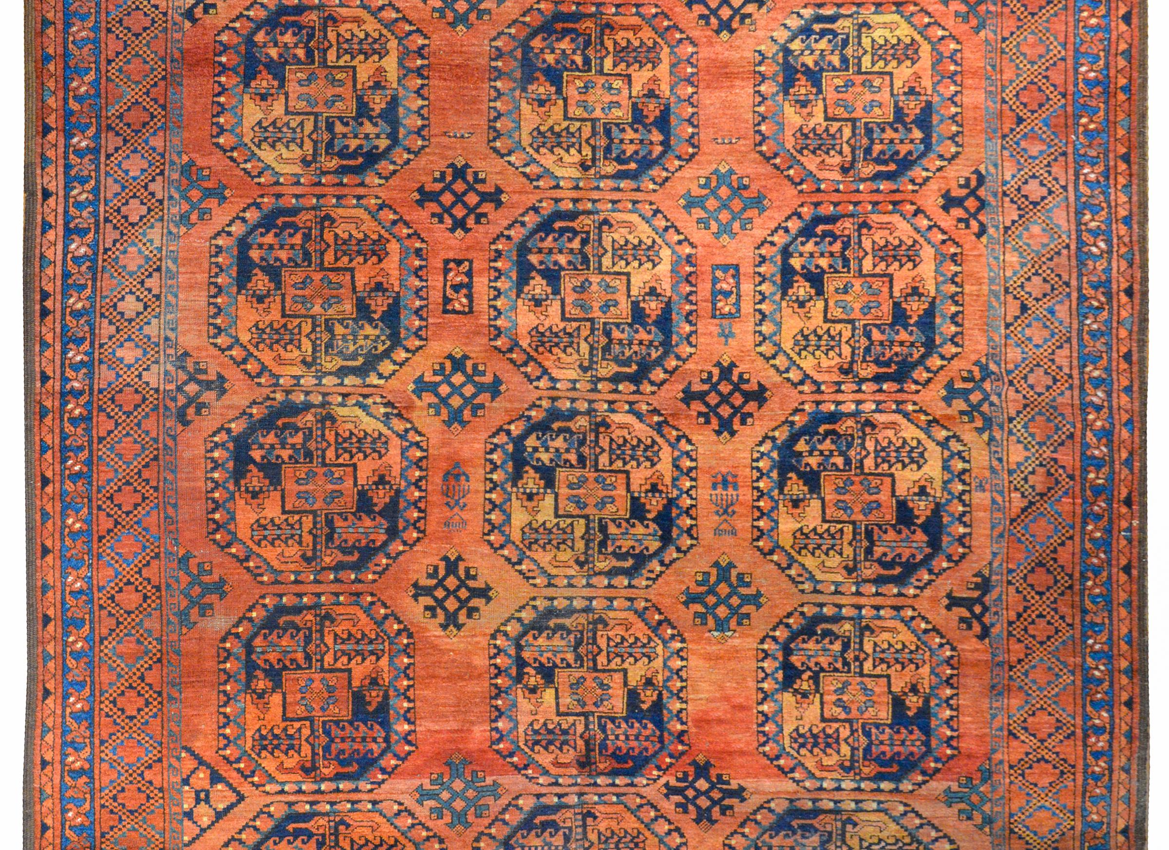 A beautiful early 20th century Afghani Ersari rug with an all-over patter of crimson and indigo medallions each woven with a stylized floral pattern and set against a fantastic abrash crimson background. The border is wonderful with multiple