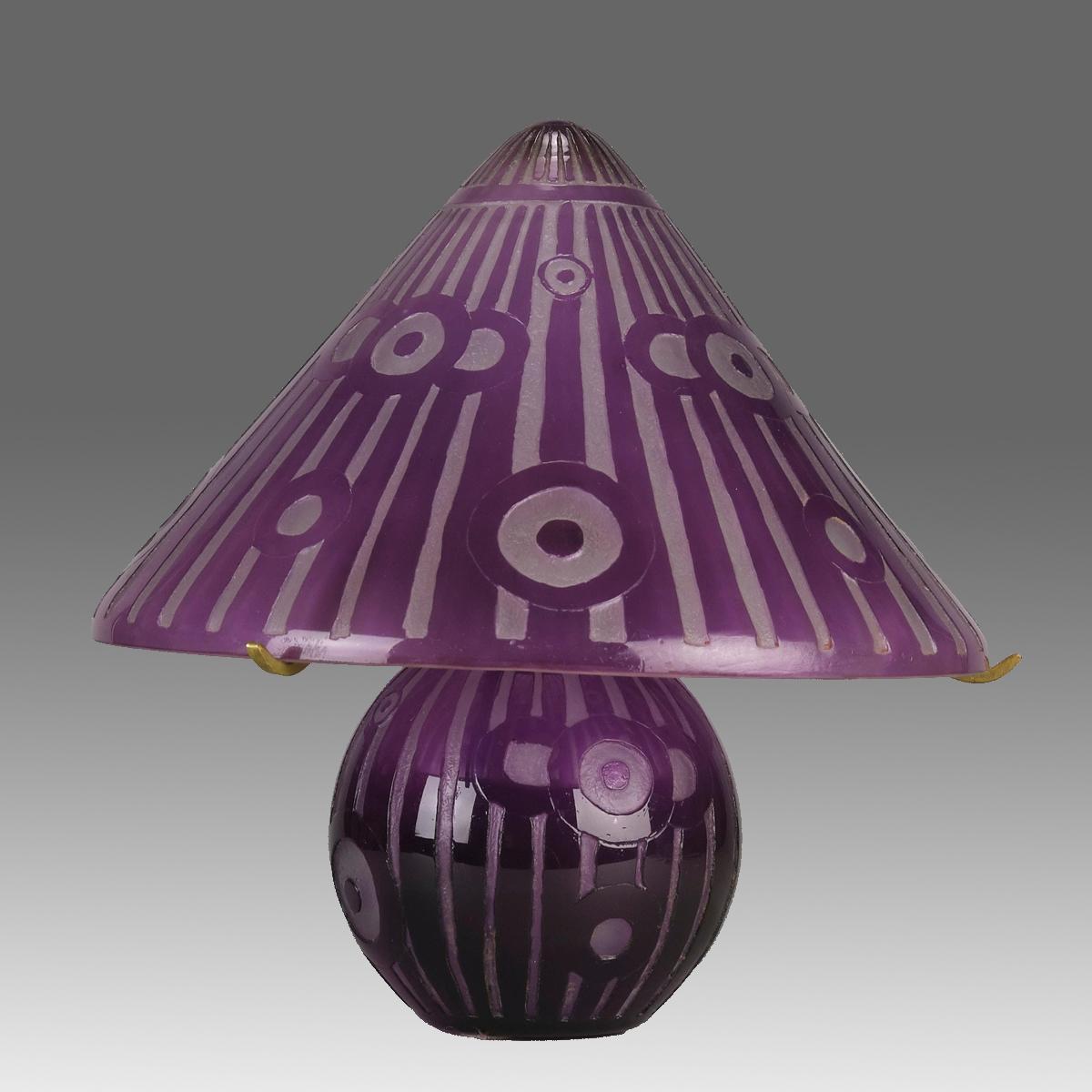 Une lampe en verre camée Art Déco du début du 20e siècle, gravée d'un motif Art Déco saisissant et enveloppée d'une couleur violette profonde, présentant d'excellentes couleurs et détails. Signé Daum Nancy sur le bord de l'abat-jour.
INFORMATIONS