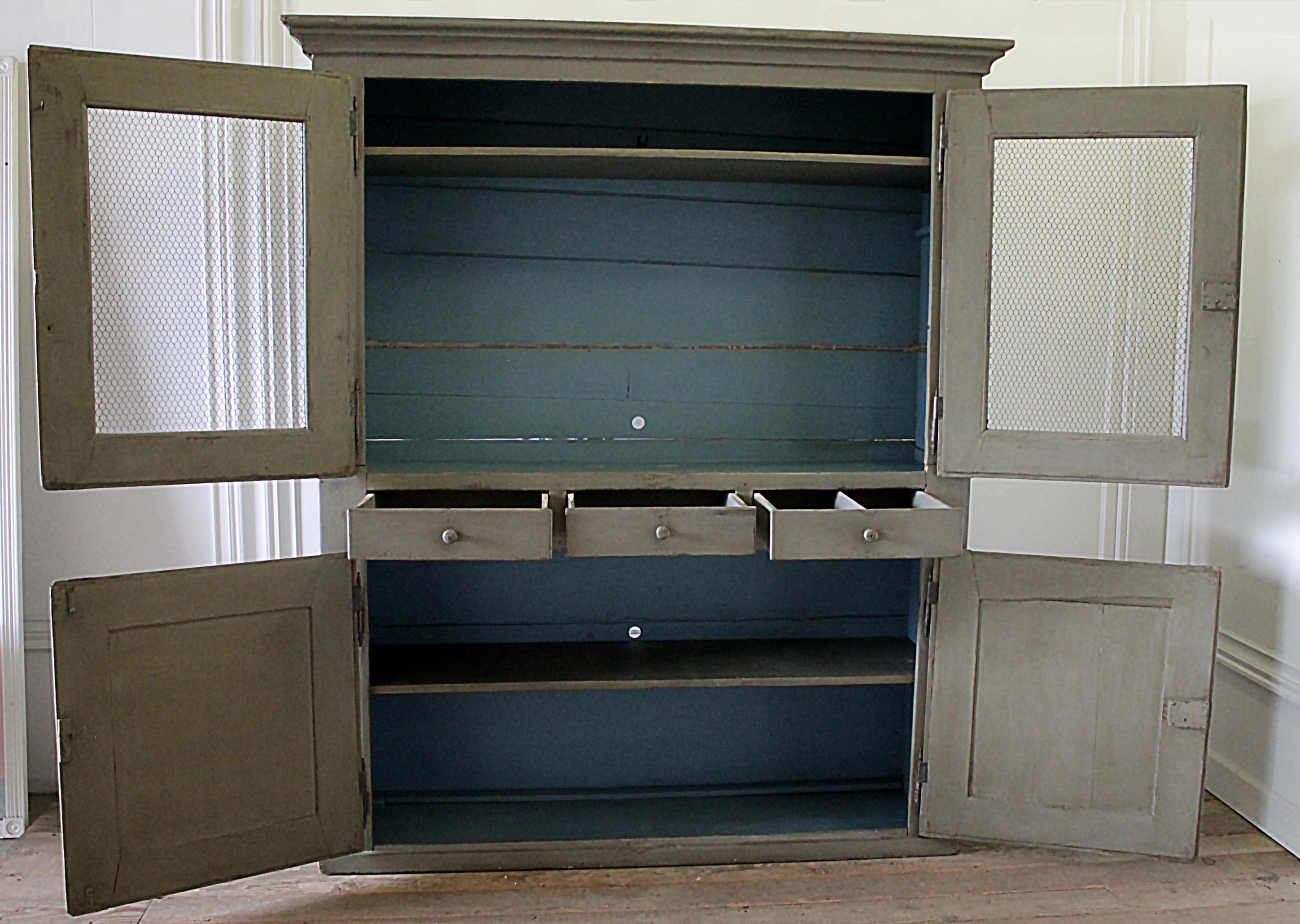 Early 20th century European farmhouse style cupboard
Painted in medium putty grey, with distressed finish, inside is a blue distressed finish, original as it came to us. This cabinet is perfect for many uses. It can hide a 55