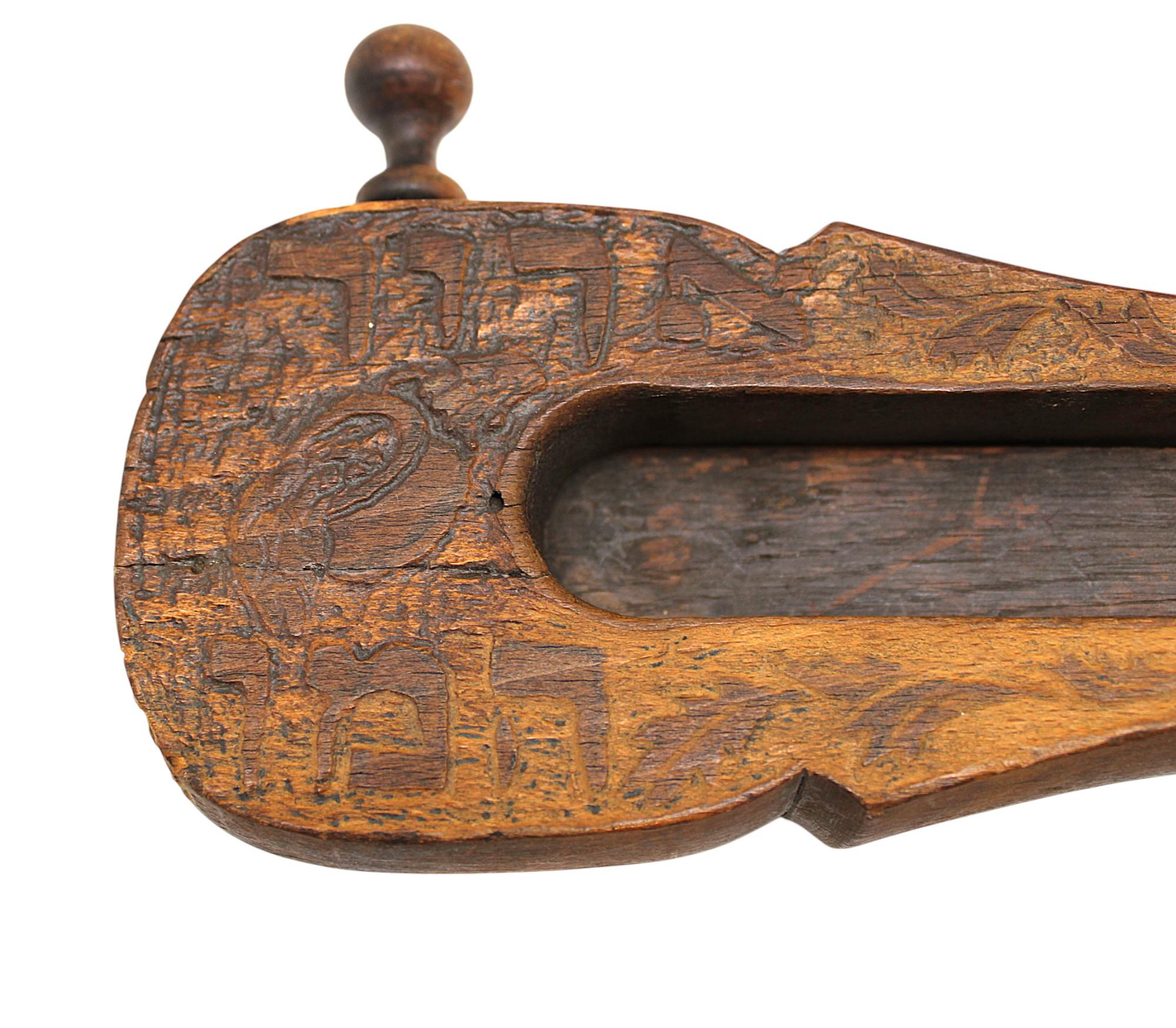 An early 20th-century European hand-carved wooden grogger (or gragger), a traditional noisemaker used during the Jewish holiday of Purim. The grogger produces a loud, clattering sound when spun, symbolizing the act of blotting out the name of Haman,