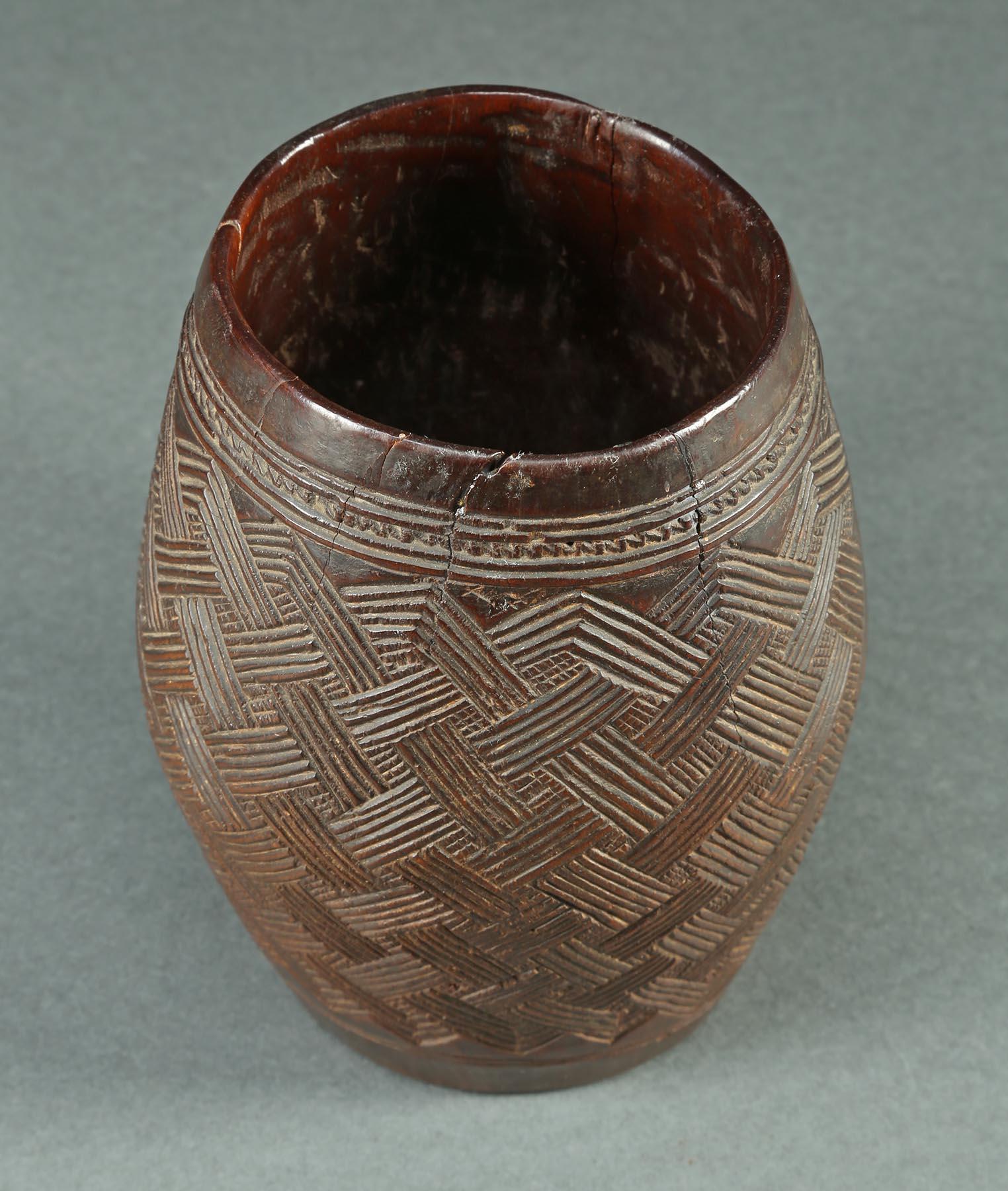 Early 20th century finely carved wood palm wine cup with carved geometric designs, Kuba people, Democratic Republic of Congo, Africa.
The intricate interlocking design is very similar to that found on the embroidered Shoowa Kuba currency cloths