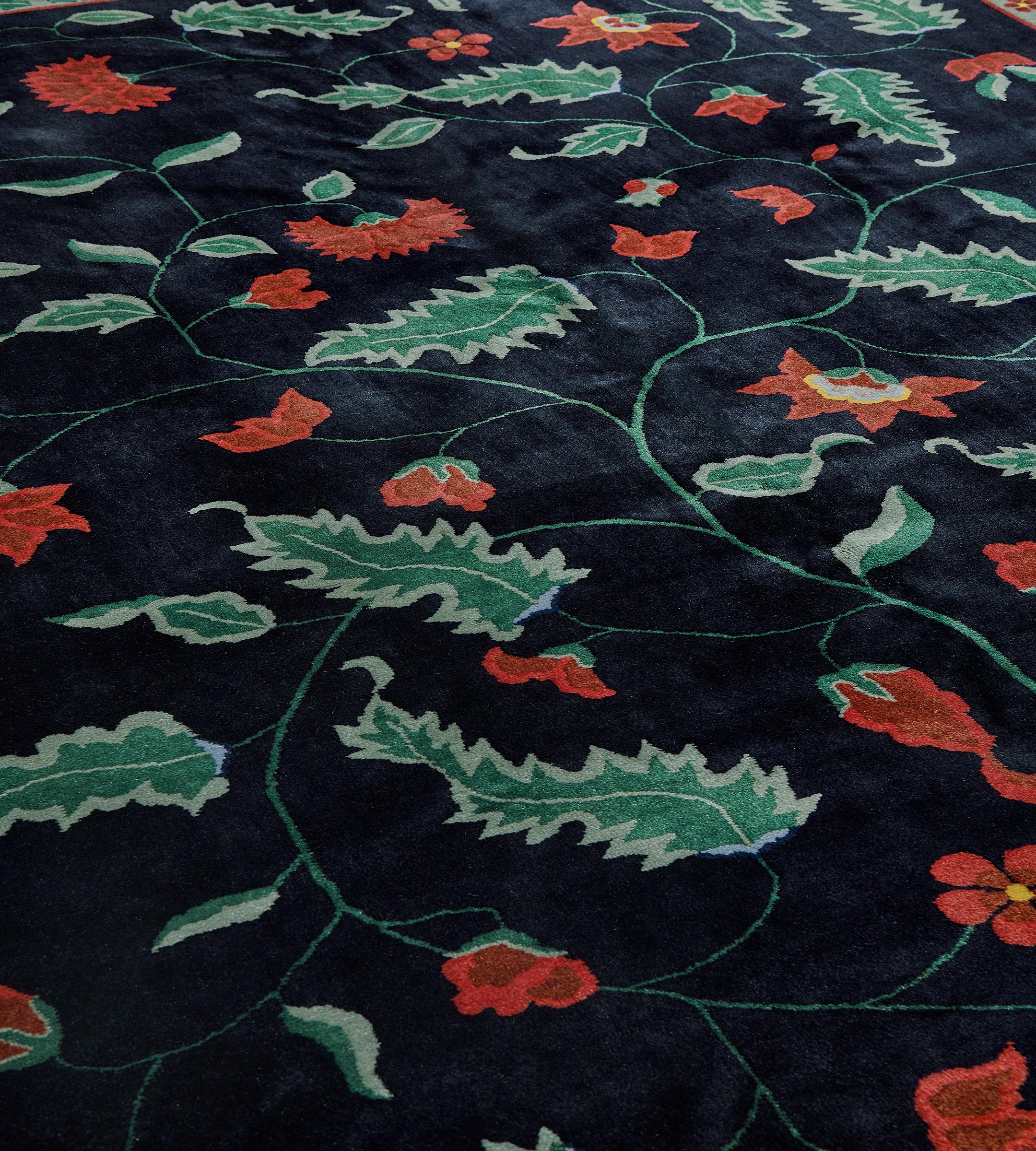 Ce tapis chinois traditionnel tissé à la main présente un élégant champ anthracite avec une vigne méandreuse audacieuse et équilibrée émettant diverses fleurs de couleur rubis, dans une bordure anthracite complémentaire avec une vigne fleurie rubis