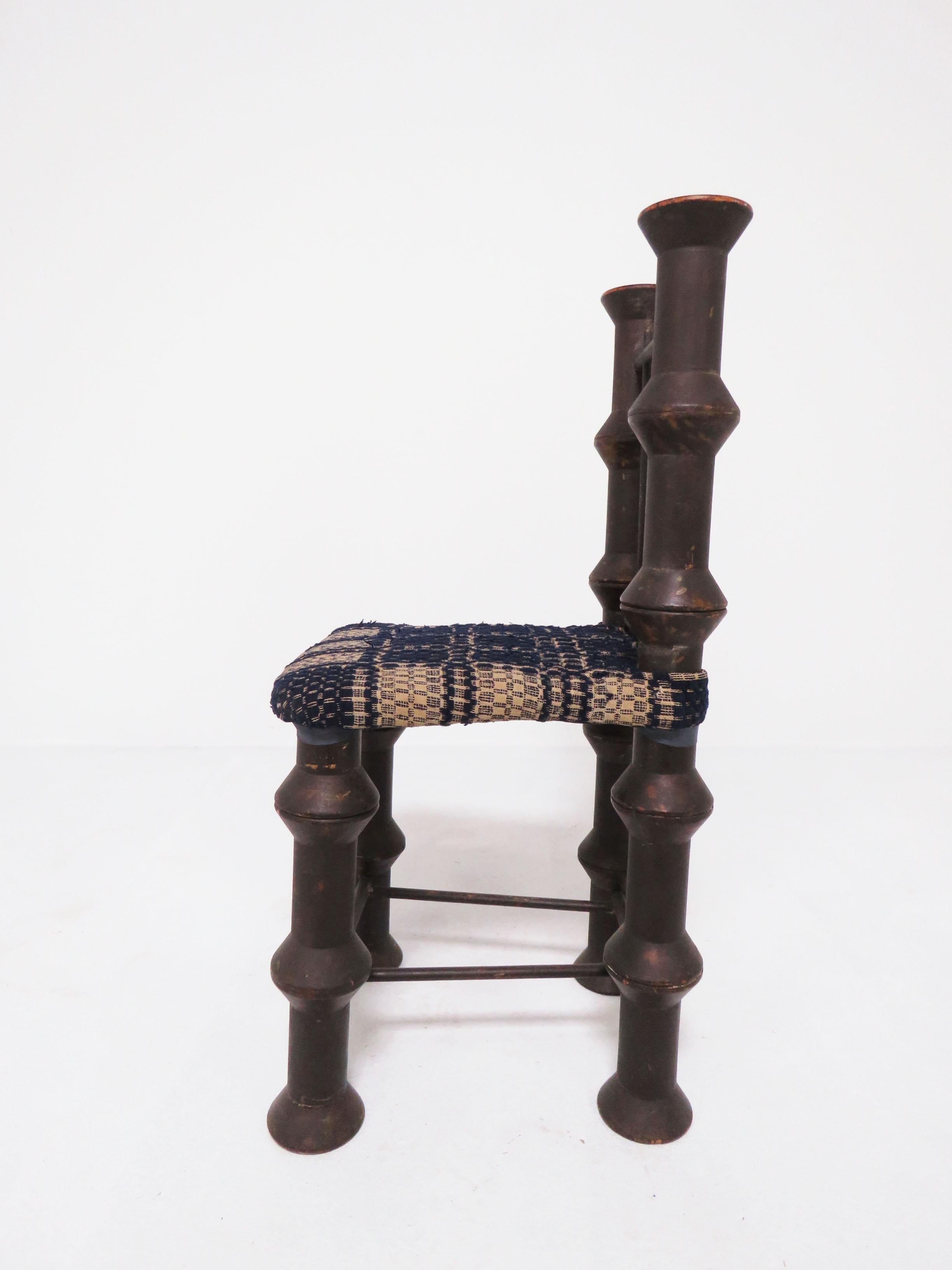 An early 20th Century folk art chair made of stacked 6” spools or “thread reels” evokes the once thriving textile industry of Massachusetts. Upholstered in a section of 19th century overshot coverlet.
