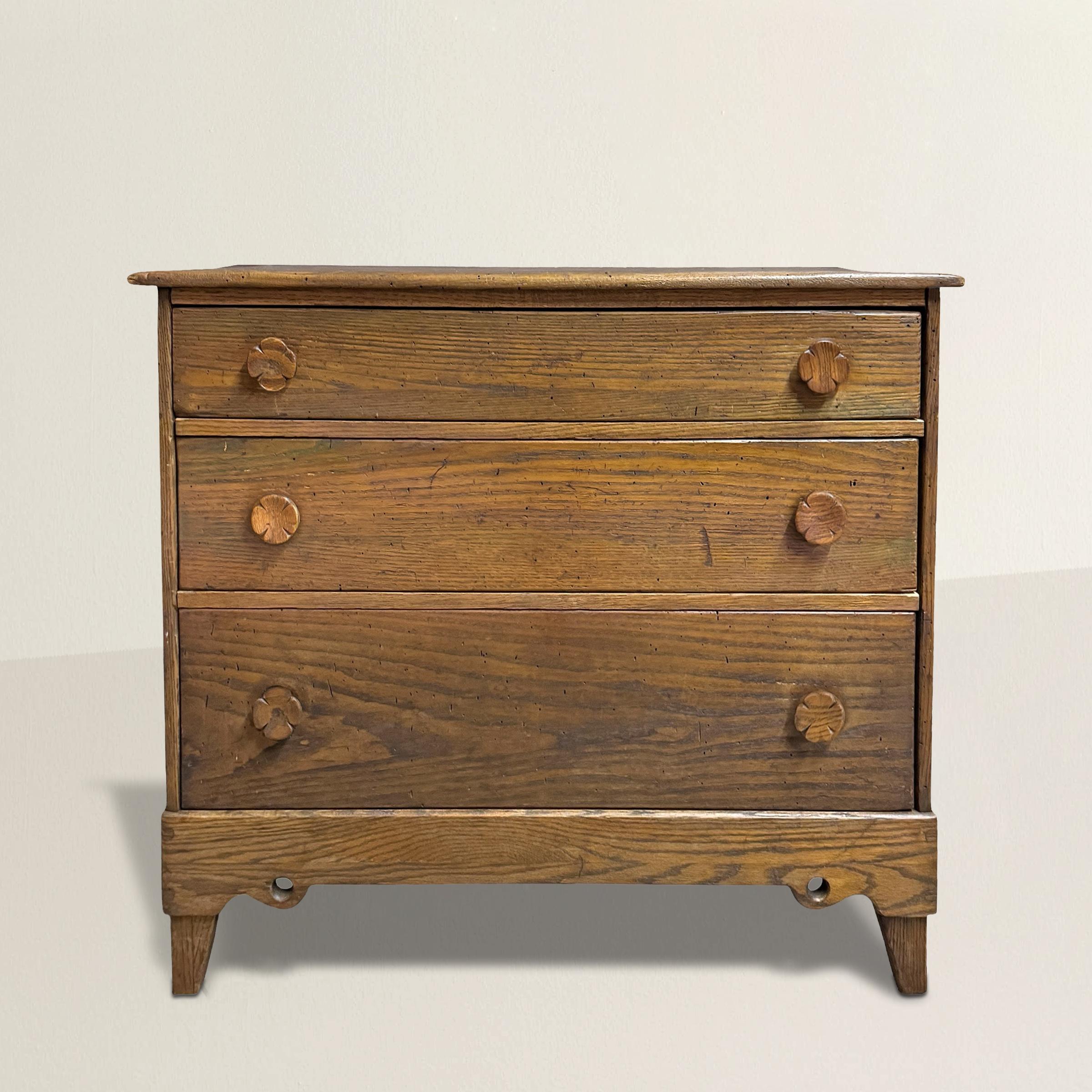 Affascinante e piena di carattere, questa cassettiera americana dell'inizio del XX secolo mostra una giocosa sensibilità folkloristica, fondendo l'artigianato rustico con un design stravagante. I pannelli in legno intagliato sono i primi a catturare