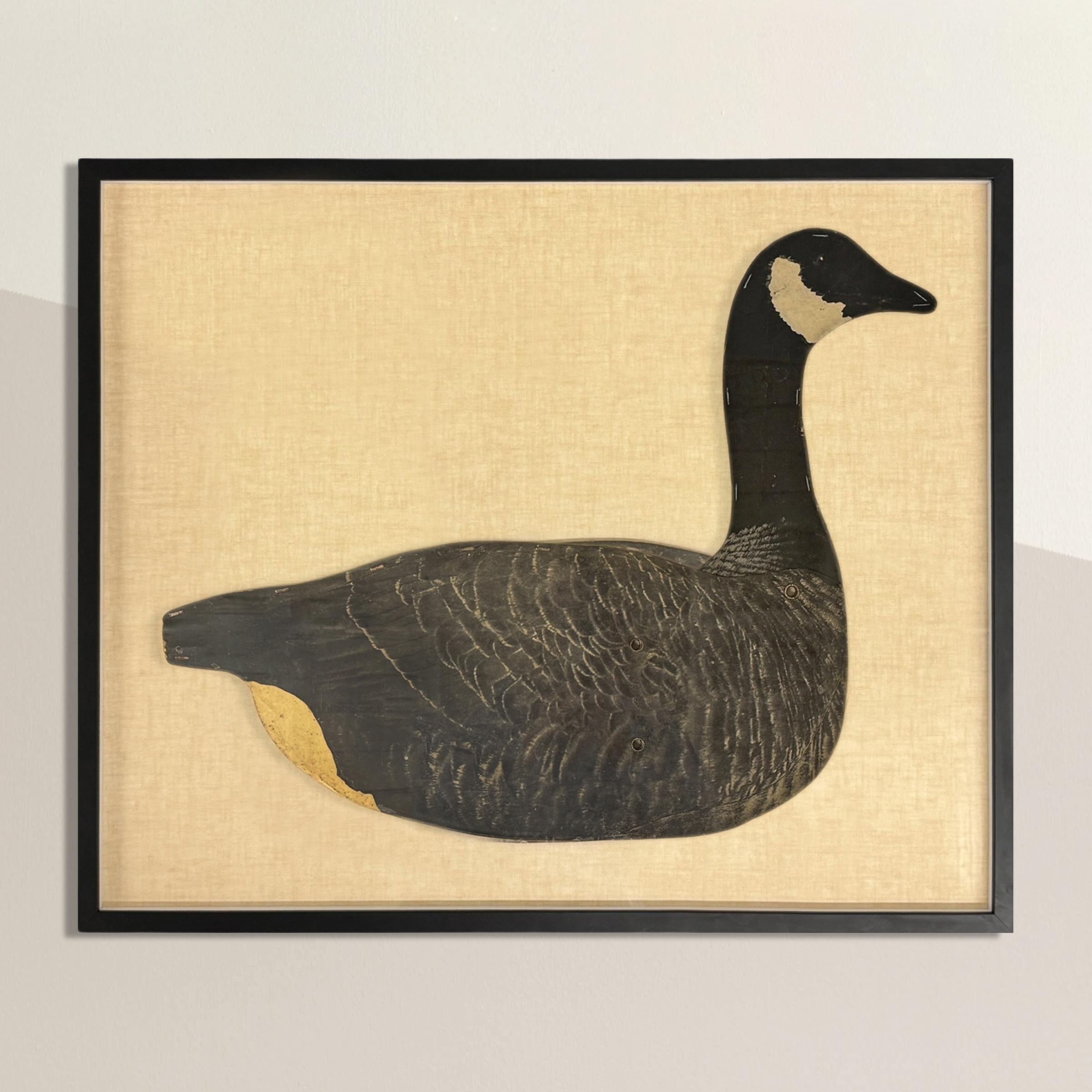 This framed American 1940s Canada Goose decoy is a striking piece of functional folk art, beautifully preserved and presented. Originally crafted from waxed cardboard, the decoy was designed to be lightweight and portable, with a metal bar inserted