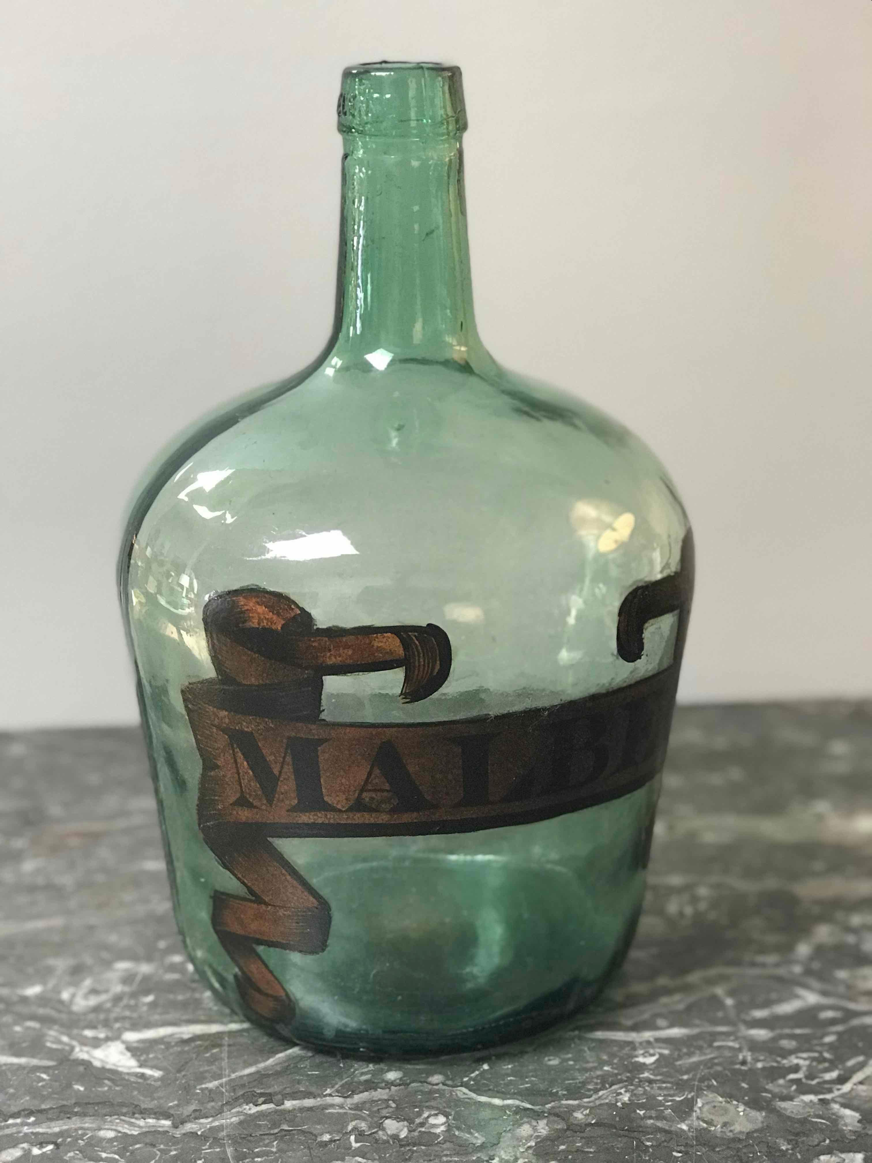 Early 20th century France green blown glass bottle with Malbec label. Perfect for serving dinner wine to guests or decorative accent piece.  