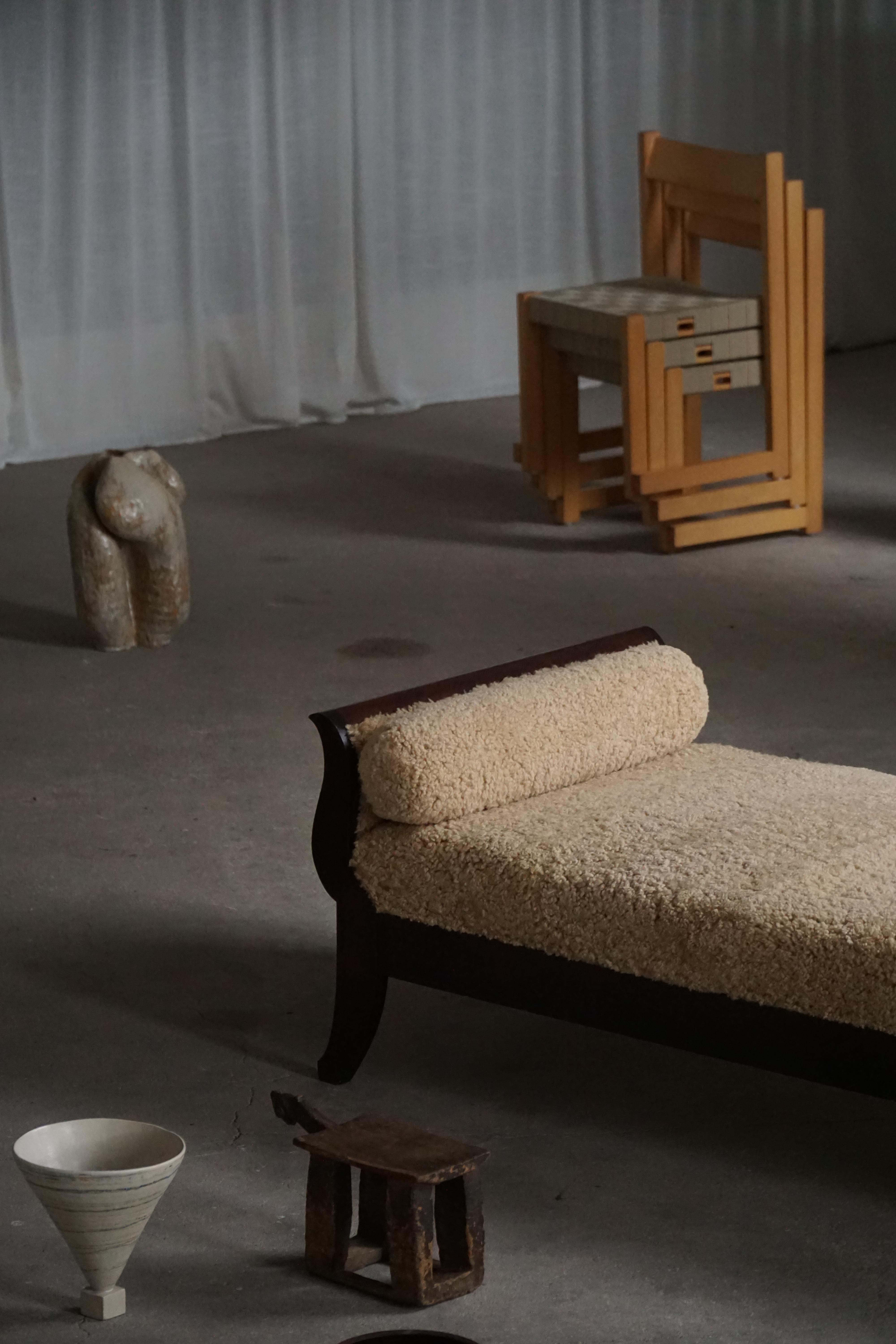 Exemple exquis de l'Art déco danois, ce lit de jour autoportant a été conçu dans les années 1920. Fabriqué par un habile ébéniste. Le cadre est en bois massif et le lit de jour a été recouvert d'une luxueuse laine d'agneau naturelle, ce qui lui