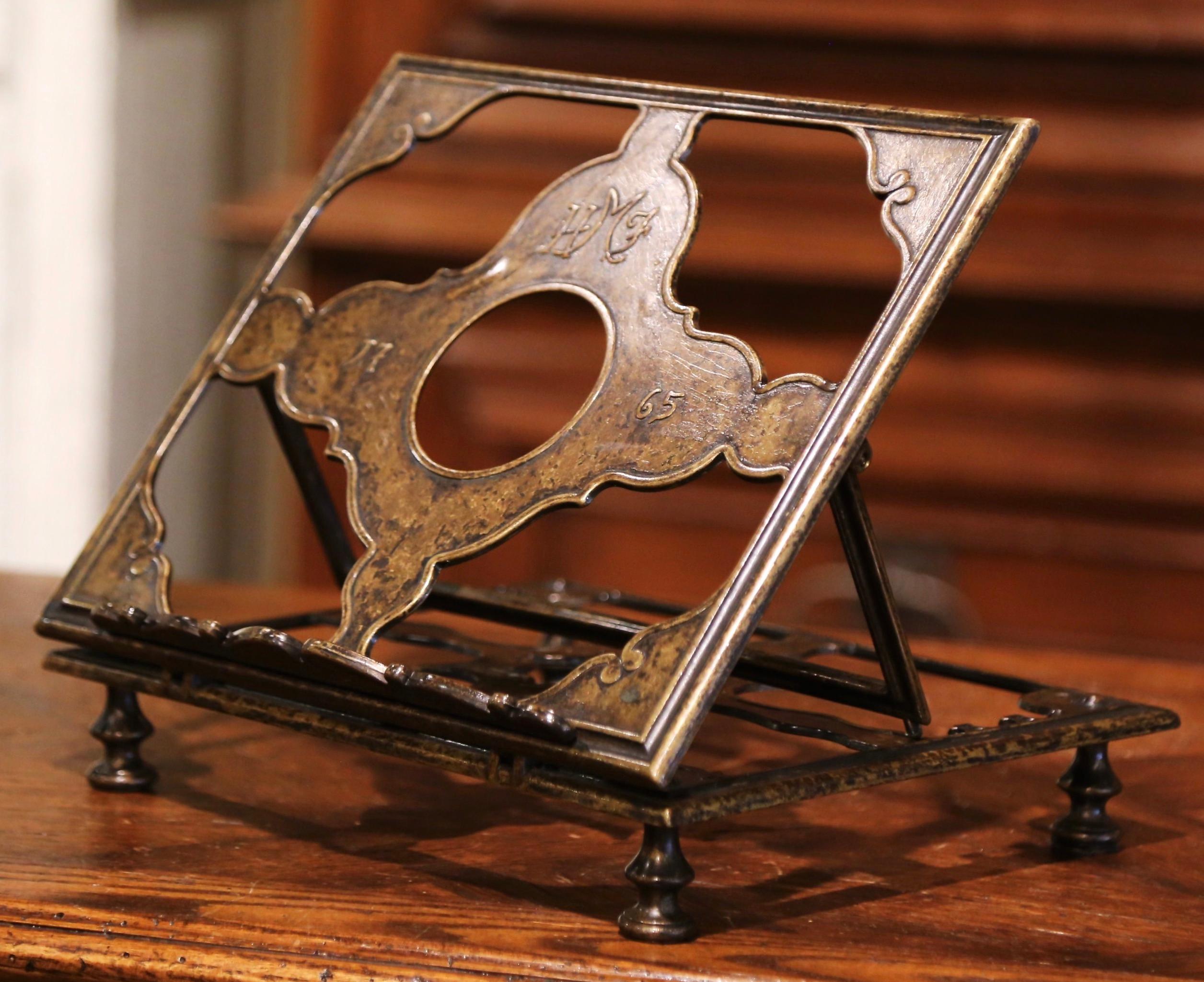 Display your Bible, music score or your favorite recipe book on this decorative, antique stand! Crafted in France circa 1920 and made of bronze, the book holder sits on four small round feet and features an adjustable top decorated with the date