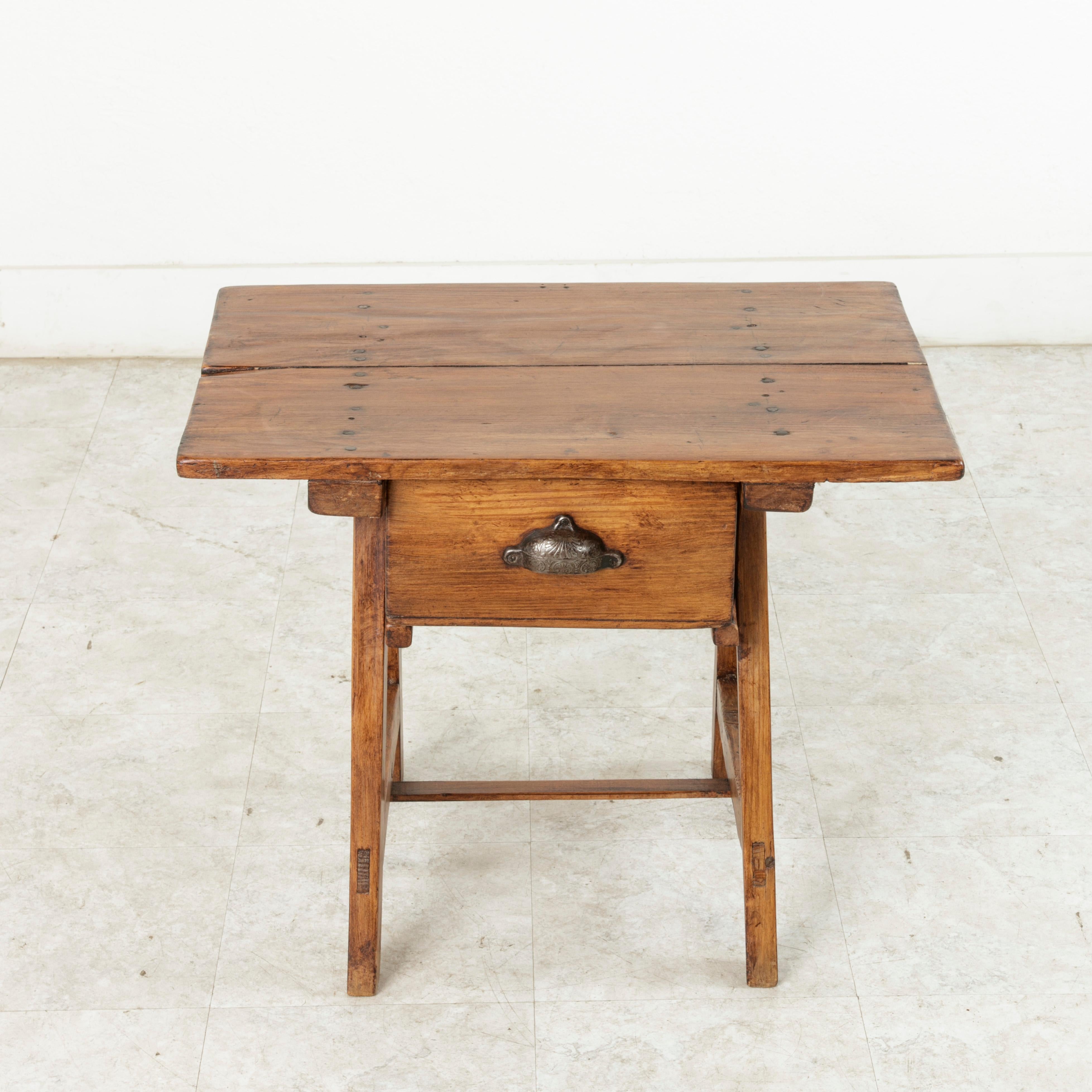 From the French Alps region of France, this early 20th century artisan-made pine table was originally constructed by a goat herder during the long hours of the day watching over his herd. Referred to as a mountain table, this piece features a top